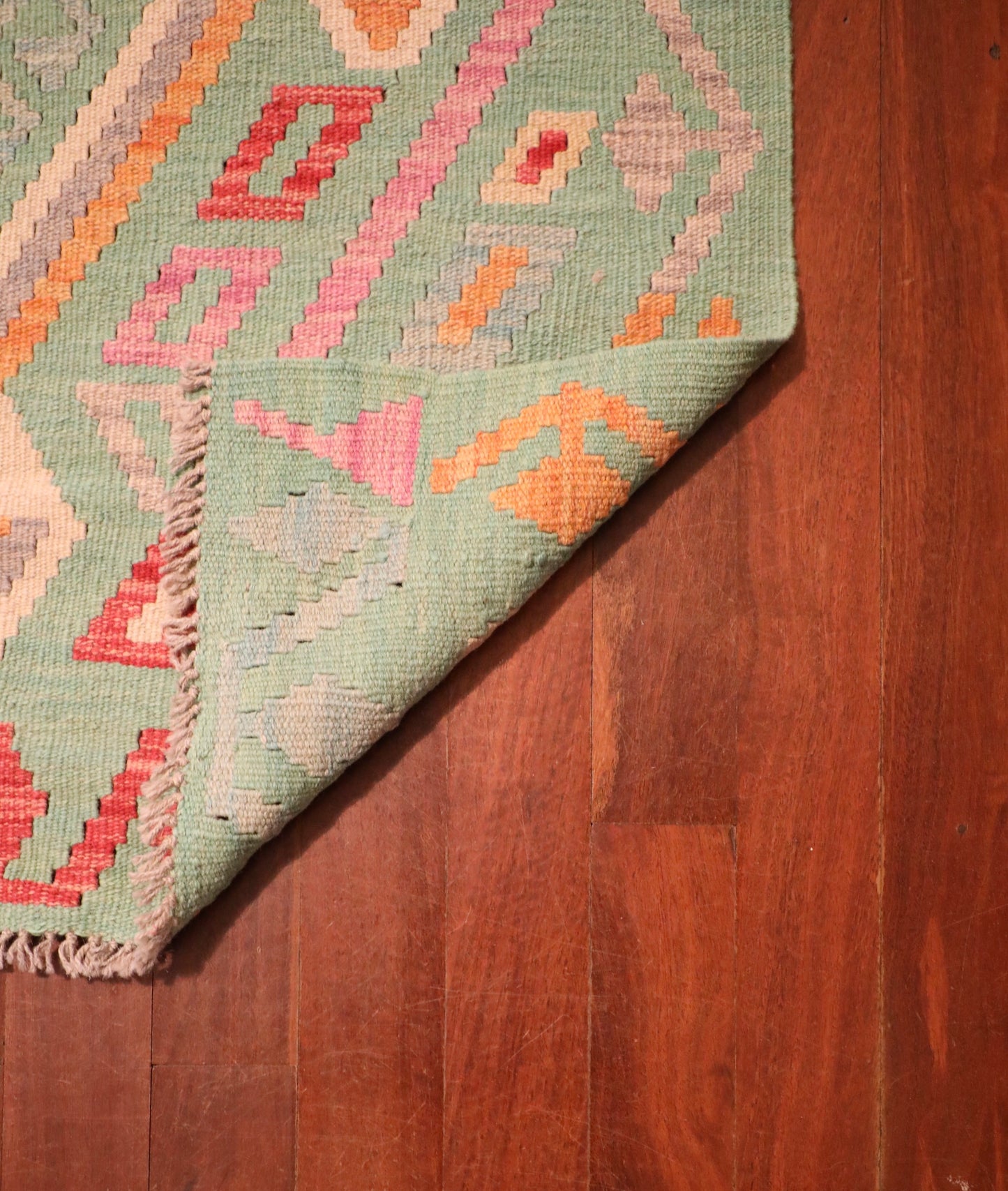 The Afghan Hand Woven Khyber Kilim - 126 X 179. Crafted using traditional vegetable dyed wool, and featuring traditional geometric designs. Colours, greens, beiges, creams, oranges. Size 126 X 179. Fold.