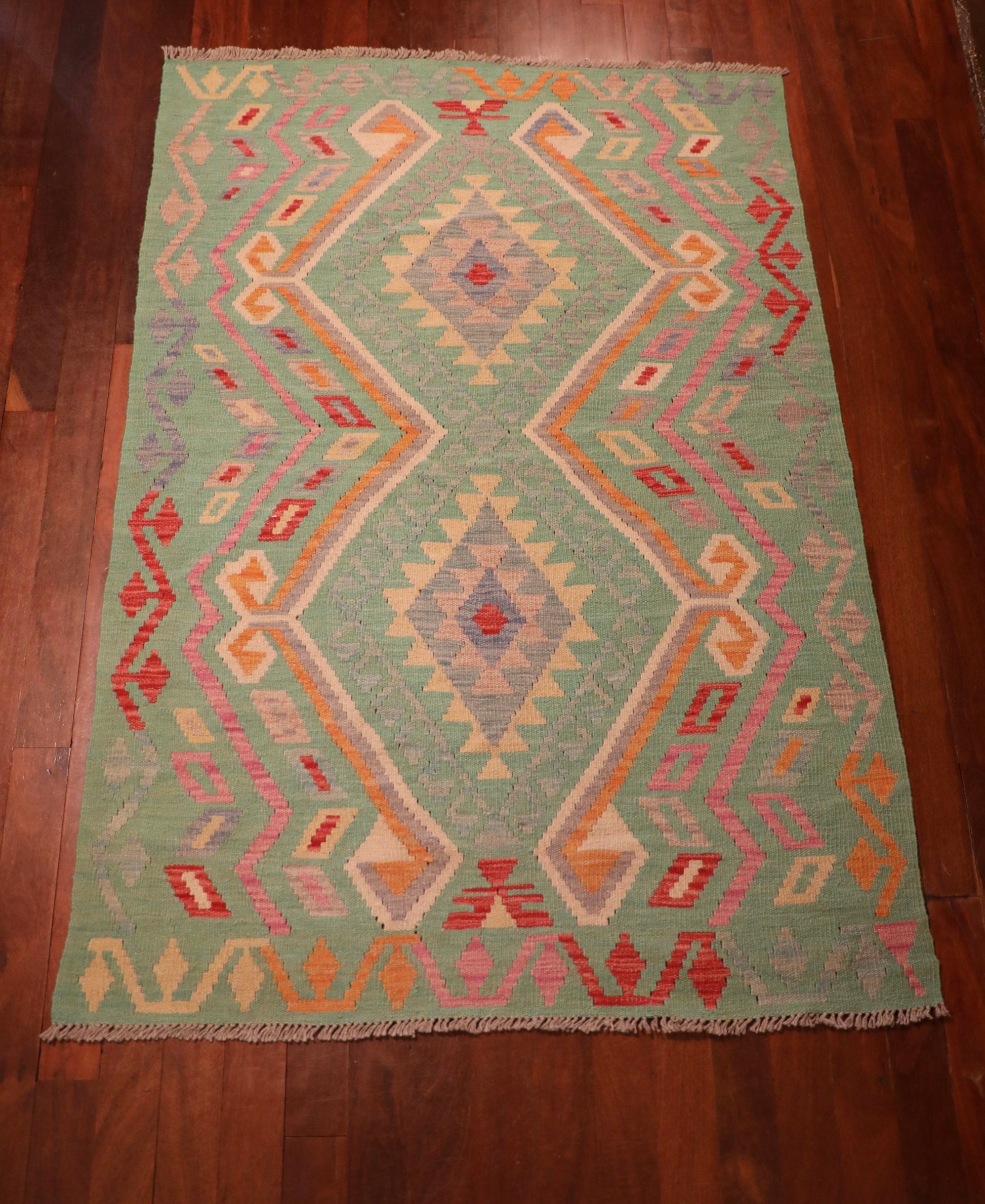 The Afghan Hand Woven Khyber Kilim - 126 X 179. Crafted using traditional vegetable dyed wool, and featuring traditional geometric designs. Colours, greens, beiges, creams, oranges. Size 126 X 179. Top.