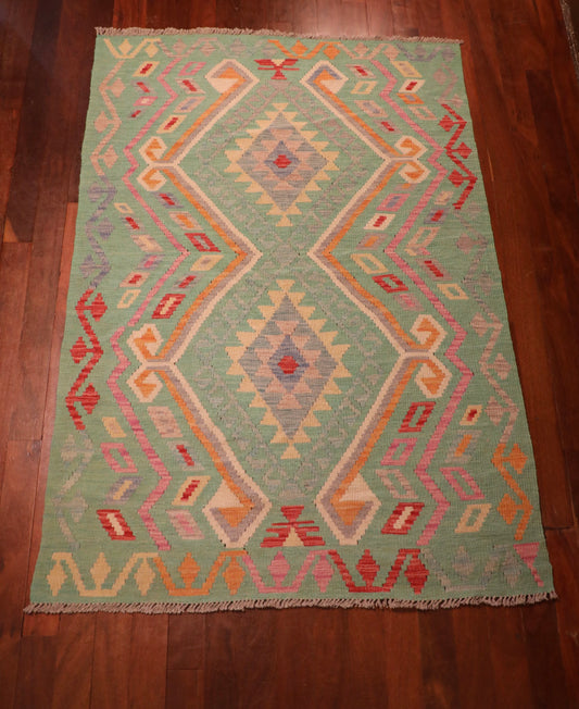 The Afghan Hand Woven Khyber Kilim - 126 X 179. Crafted using traditional vegetable dyed wool, and featuring traditional geometric designs. Colours, greens, beiges, creams, oranges. Size 126 X 179. Top.