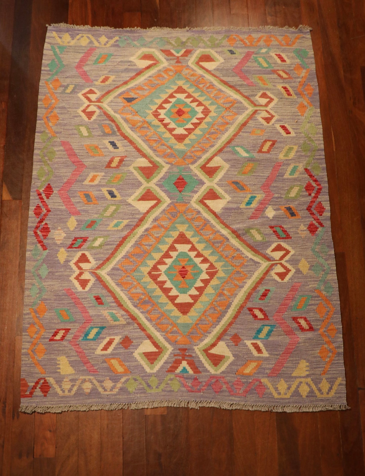 The Afghan Hand Woven Khyber Kilim - 127 X 174. Crafted using traditional vegetable dyed wool, and featuring traditional geometric designs. Colours, lavenders, beiges, creams, oranges. Size 127 X 174. Top.