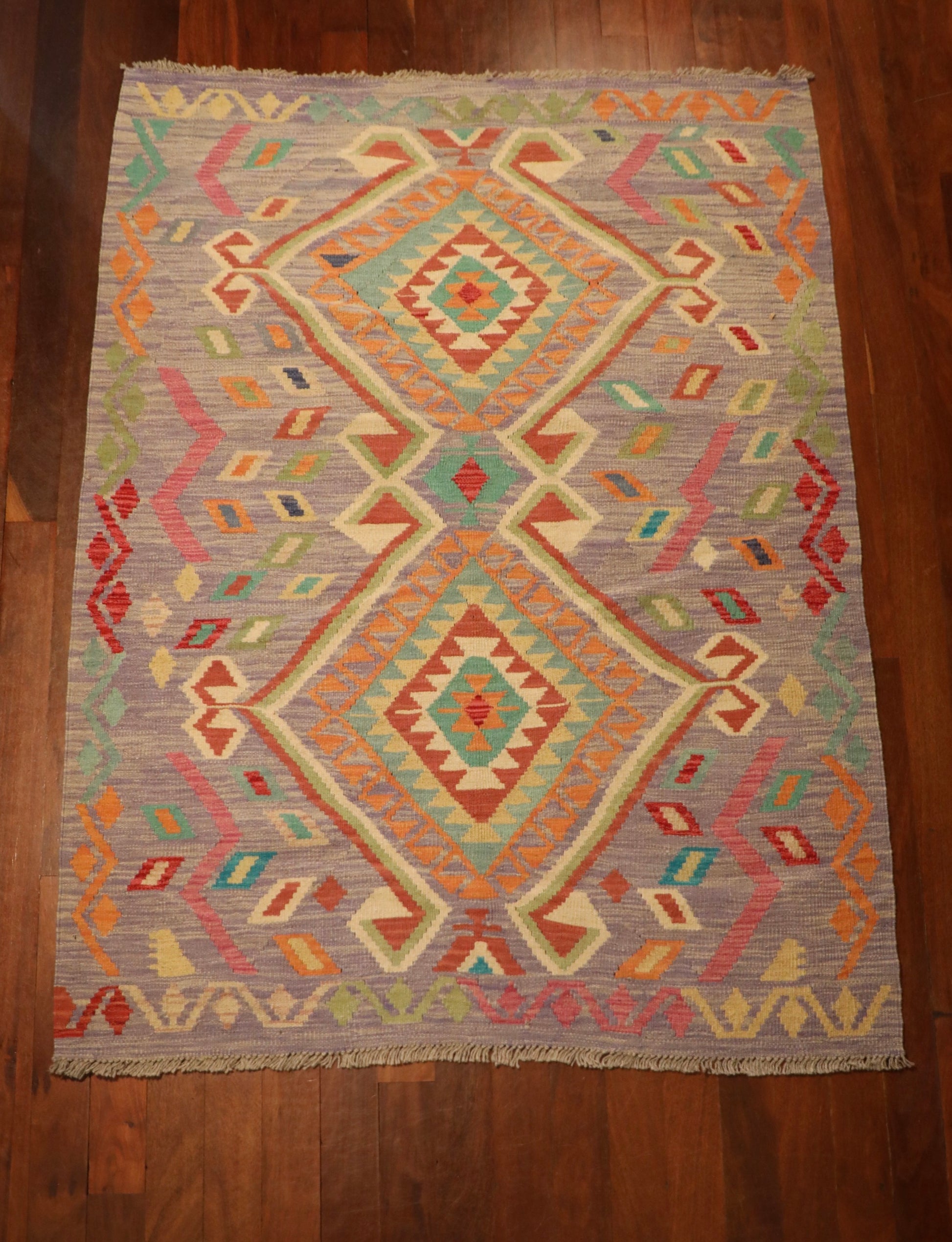 The Afghan Hand Woven Khyber Kilim - 127 X 174. Crafted using traditional vegetable dyed wool, and featuring traditional geometric designs. Colours, lavenders, beiges, creams, oranges. Size 127 X 174. Top.