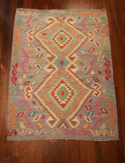 The Afghan Hand Woven Khyber Kilim - 127 X 174. Crafted using traditional vegetable dyed wool, and featuring traditional geometric designs. Colours, lavenders, beiges, creams, oranges. Size 127 X 174. Top.