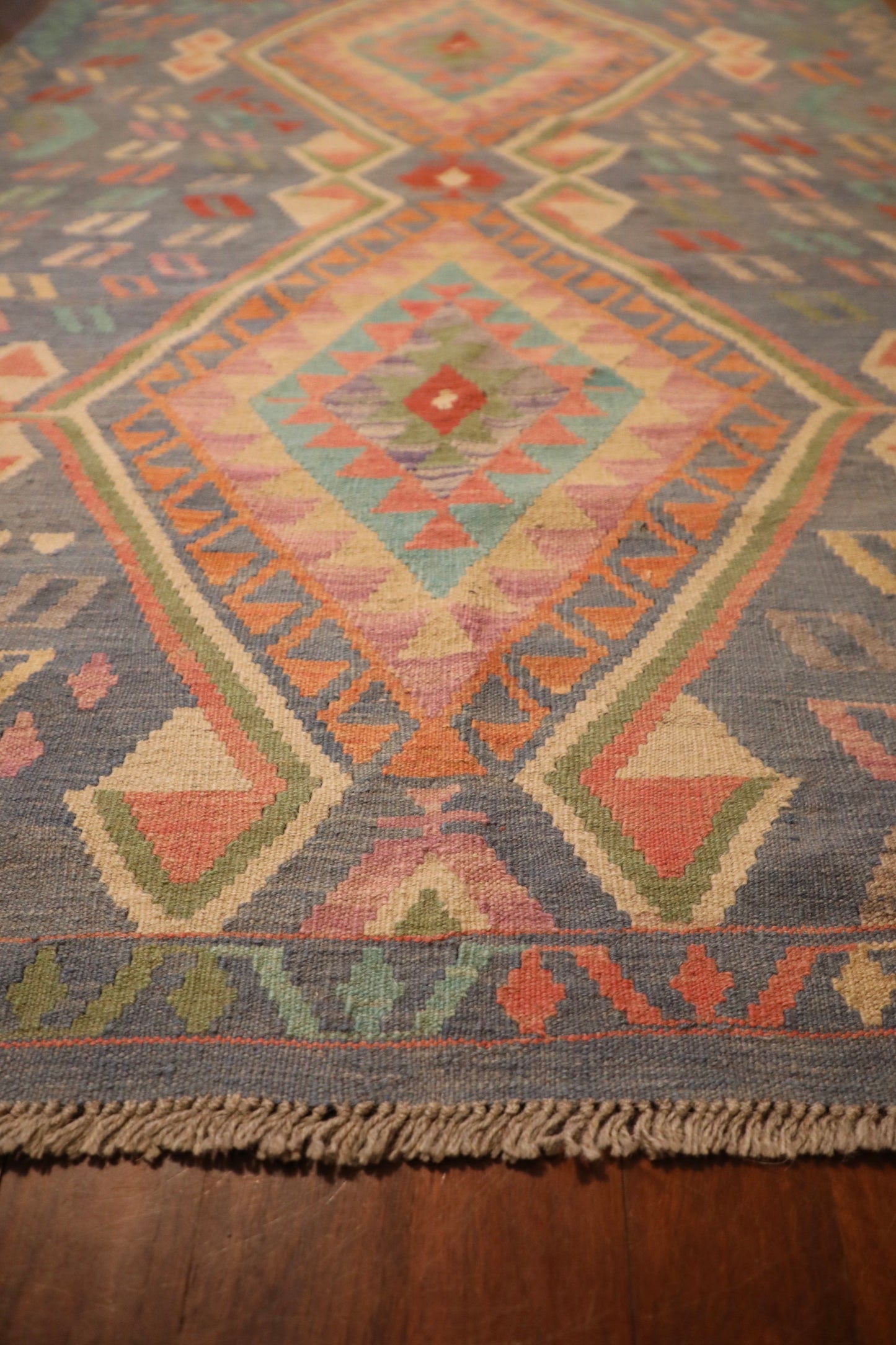 The Afghan Hand Woven Khyber Kilim - 130 X 193. Crafted using traditional vegetable dyed wool, and featuring traditional geometric designs. Colours, blues, lavenders, beiges, creams, oranges. Size 130 X 193. Angle.
