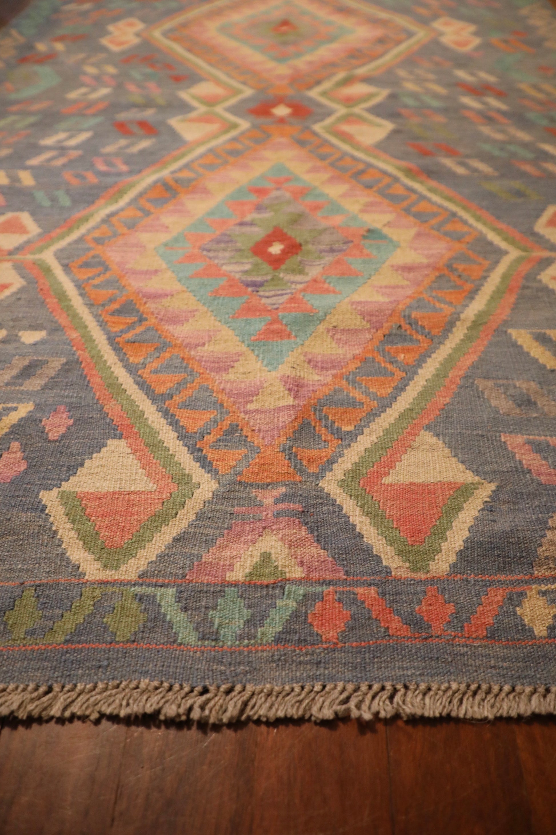 The Afghan Hand Woven Khyber Kilim - 130 X 193. Crafted using traditional vegetable dyed wool, and featuring traditional geometric designs. Colours, blues, lavenders, beiges, creams, oranges. Size 130 X 193. Angle.
