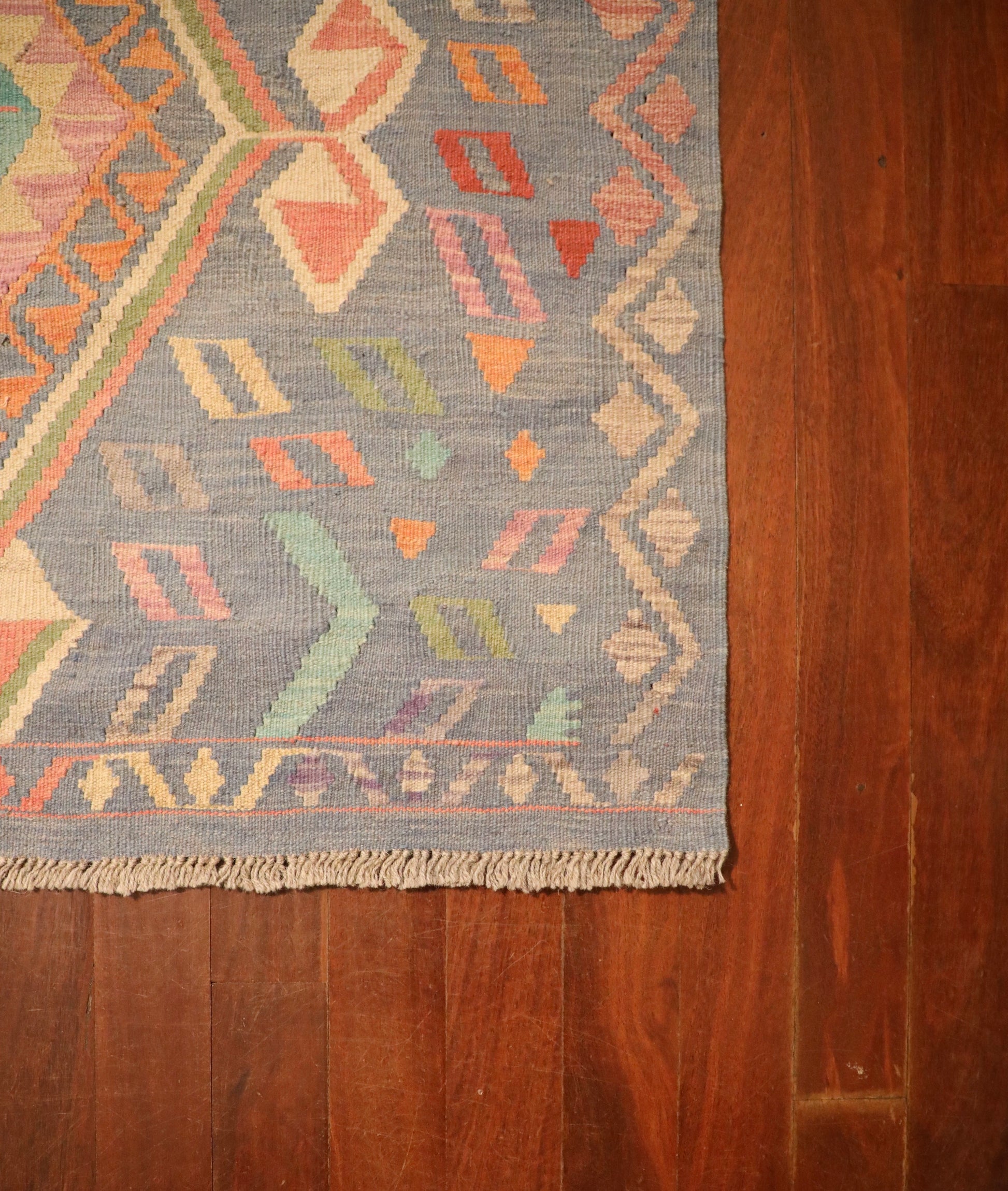The Afghan Hand Woven Khyber Kilim - 130 X 193. Crafted using traditional vegetable dyed wool, and featuring traditional geometric designs. Colours, blues, lavenders, beiges, creams, oranges. Size 130 X 193. Corner.