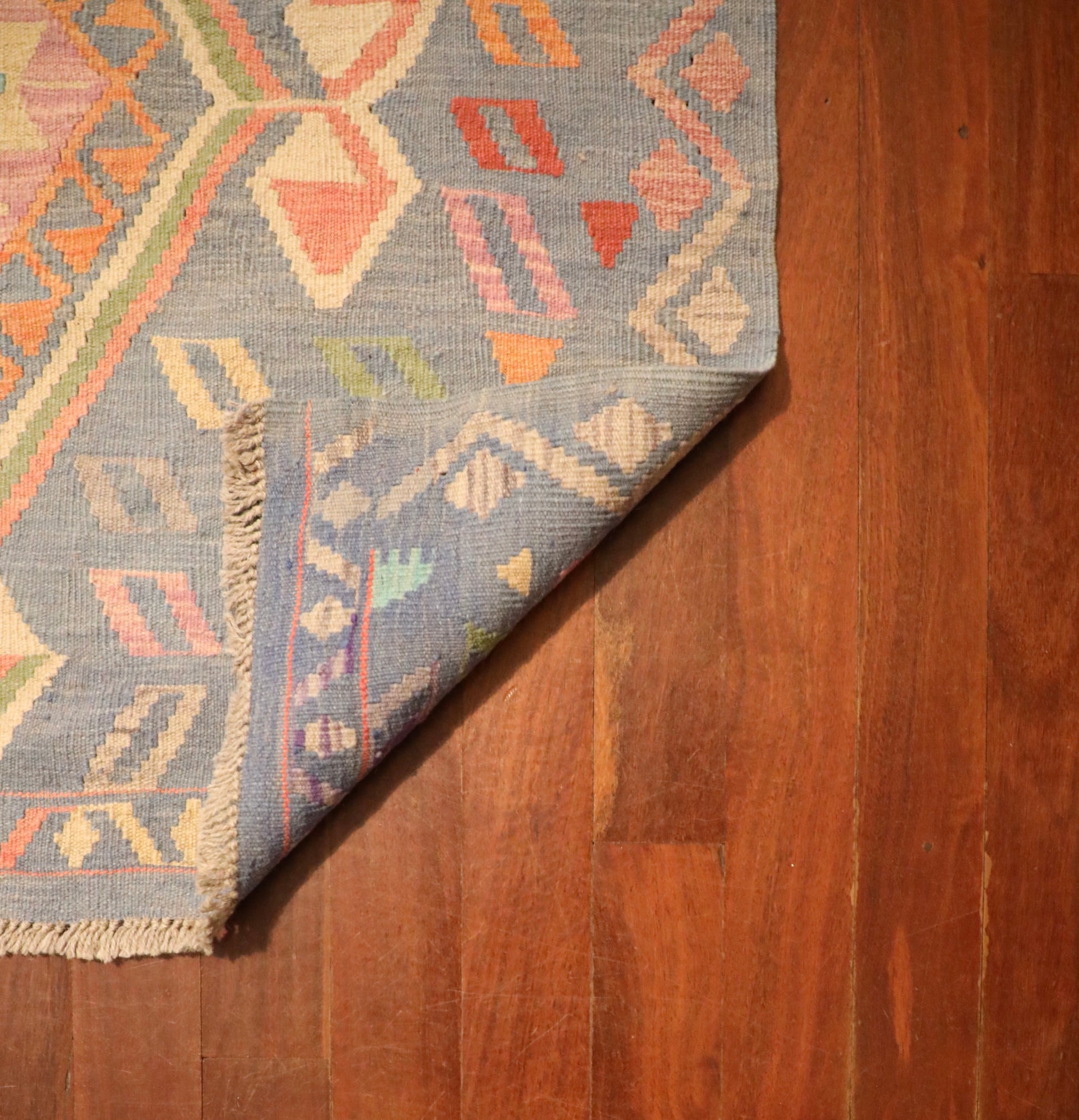 The Afghan Hand Woven Khyber Kilim - 130 X 193. Crafted using traditional vegetable dyed wool, and featuring traditional geometric designs. Colours, blues, lavenders, beiges, creams, oranges. Size 130 X 193. Fold.