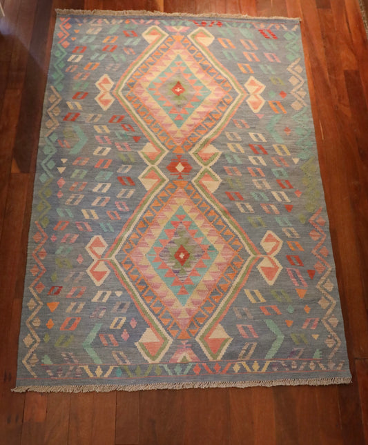 The Afghan Hand Woven Khyber Kilim - 130 X 193. Crafted using traditional vegetable dyed wool, and featuring traditional geometric designs. Colours, blues, lavenders, beiges, creams, oranges. Size 130 X 193. Top.