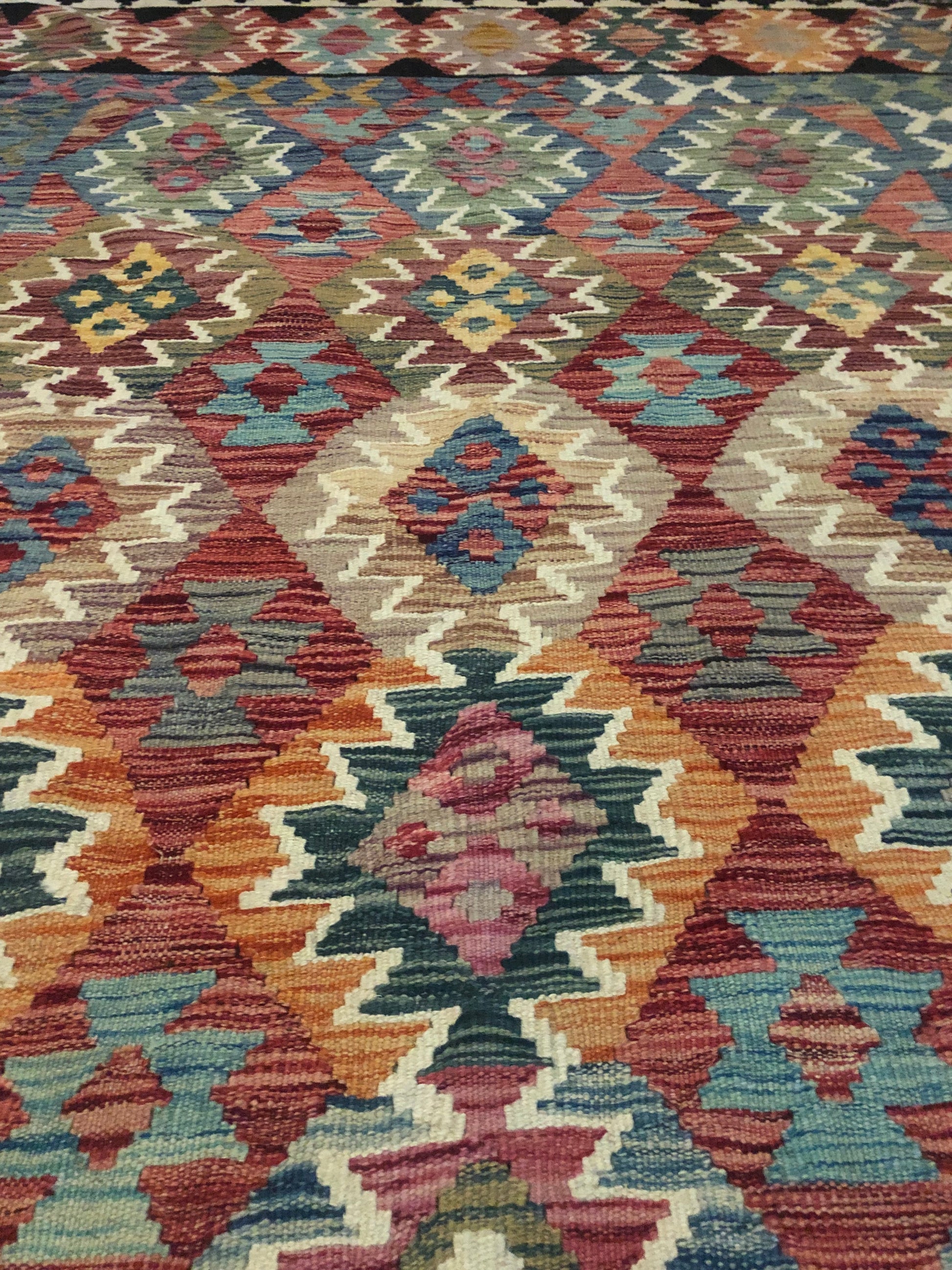 The Afghan Hand Woven Khyber Kilim - 202 X 290.  Crafted using traditional vegetable dyed wool, and featuring traditional geometric designs. Colours, blacks, blues, creams, reds, oranges and yellows. Size 202 X 290. Close.