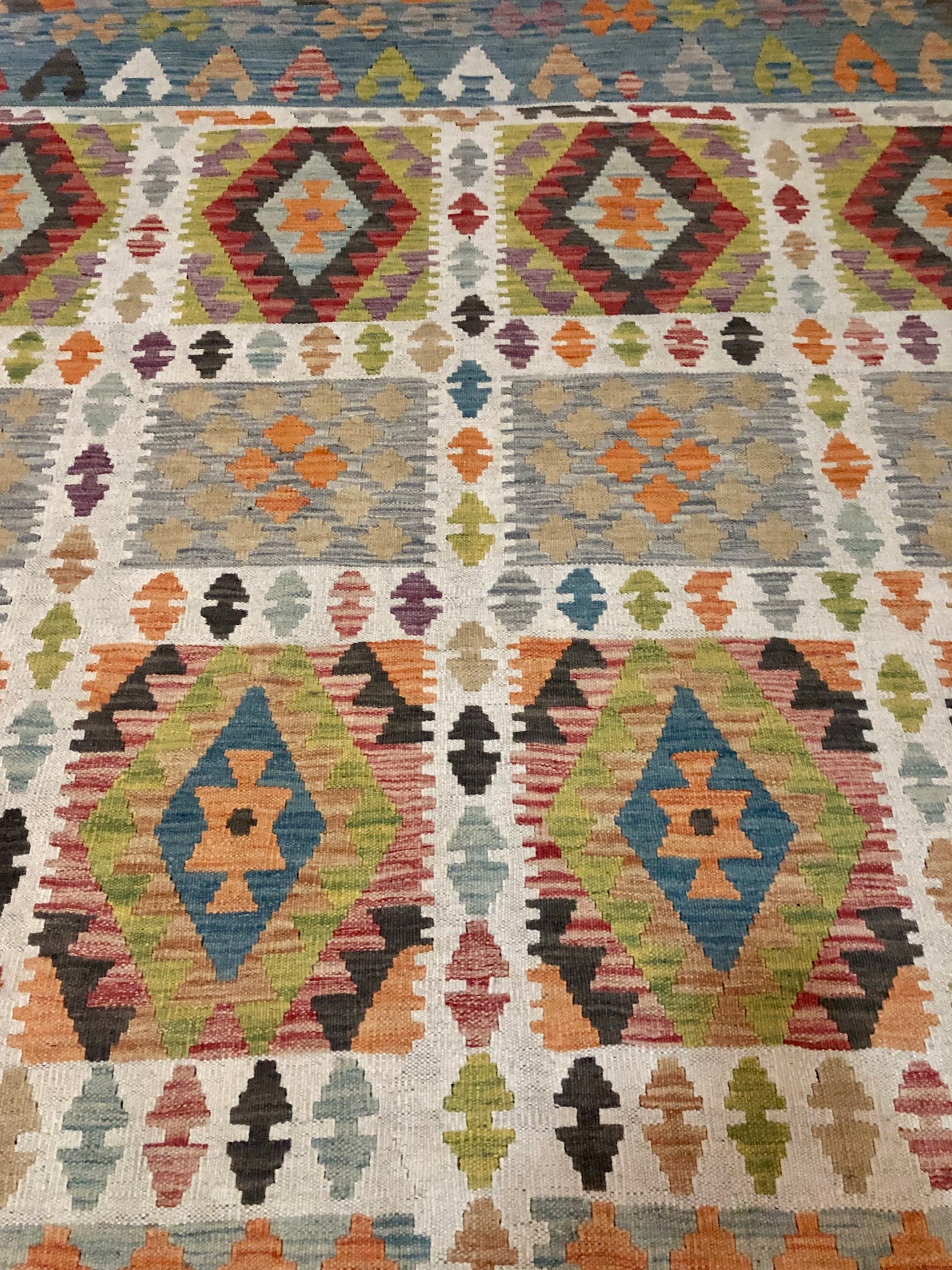 The Afghan Hand Woven Wool Khyber Kilim - 215 X 289. Crafted using traditional vegetable dyed wool, and featuring traditional geometric designs. Colours, greens, brown, cream, oranges, teals. Size 215 X 289.Close.