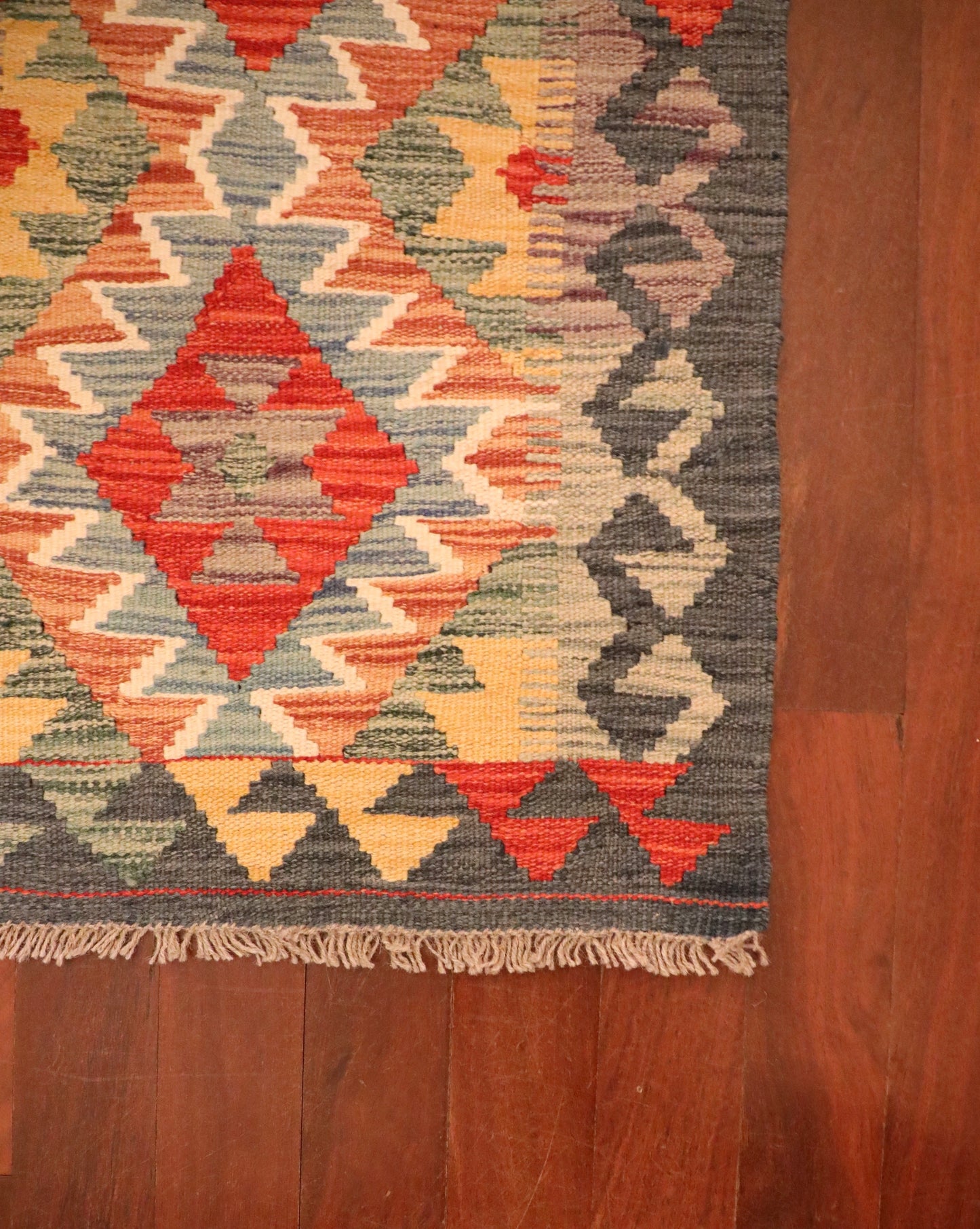The Afghan Hand Woven Khyber Kilim - 57 X 91. Crafted using traditional vegetable dyed wool, and featuring traditional geometric designs. Colours, dark greys, beiges, blues, creams, light greens, light blues and yellows. Size 57 X 91. Corner.
