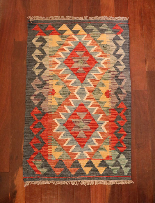 The Afghan Hand Woven Khyber Kilim - 57 X 91. Crafted using traditional vegetable dyed wool, and featuring traditional geometric designs. Colours, dark greys, beiges, blues, creams, light greens, light blues and yellows. Size 57 X 91. Top.