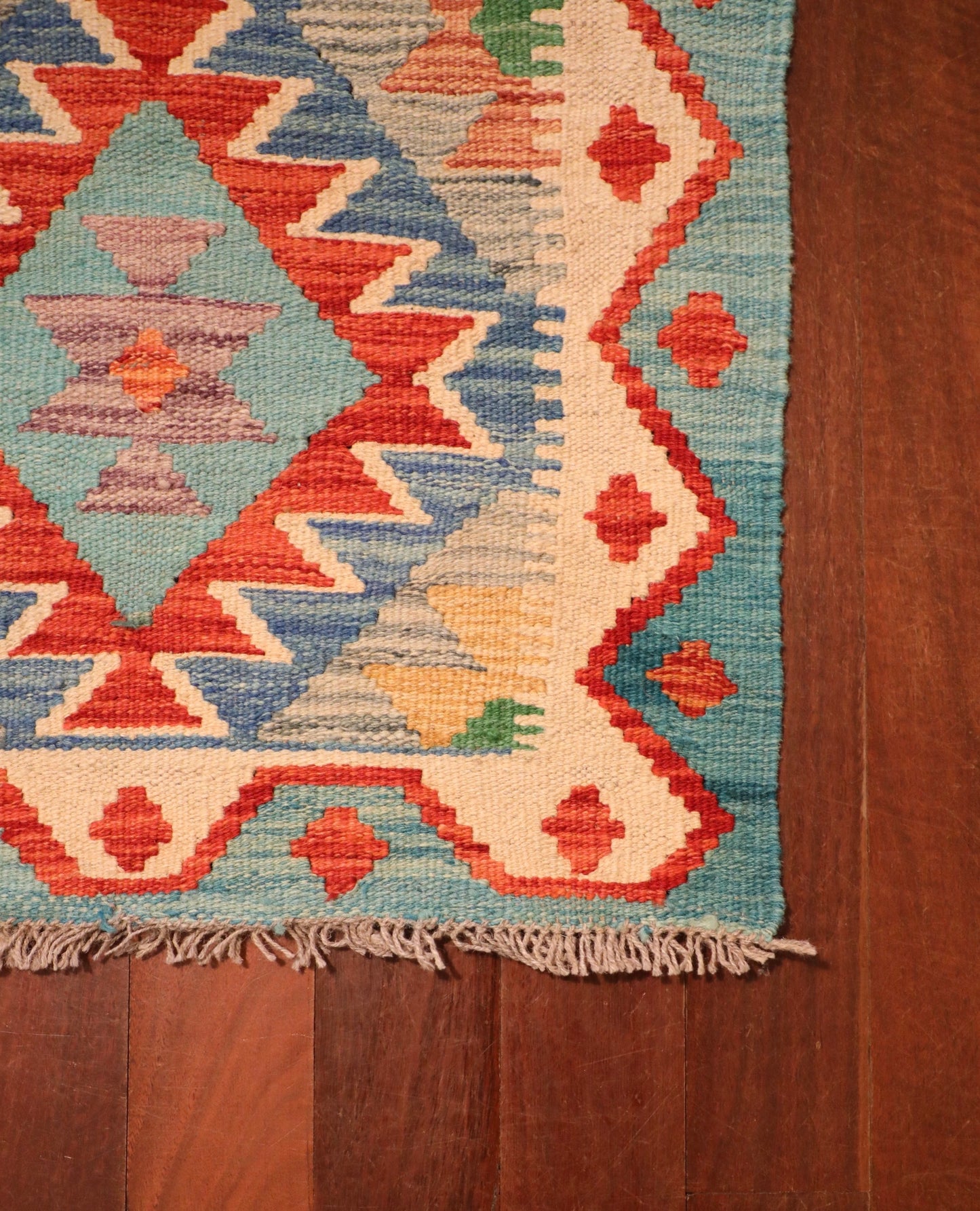  The Afghan Hand Woven Khyber Kilim - 58 X 88. Crafted using traditional vegetable dyed wool, and featuring traditional geometric designs. Colours, Dark oranges, creams, light greens, light blues yellows. Size 58 X 88. Corner.