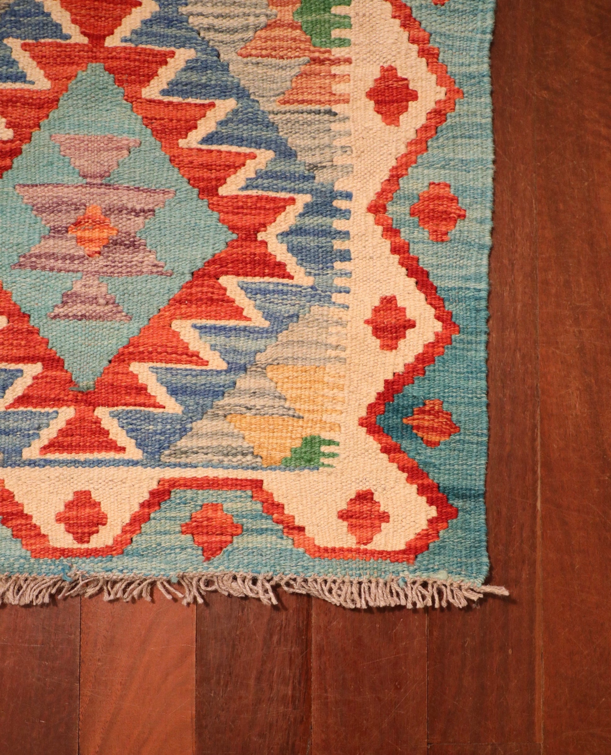 The Afghan Hand Woven Khyber Kilim - 58 X 88. Crafted using traditional vegetable dyed wool, and featuring traditional geometric designs. Colours, Dark oranges, creams, light greens, light blues yellows. Size 58 X 88. Corner.