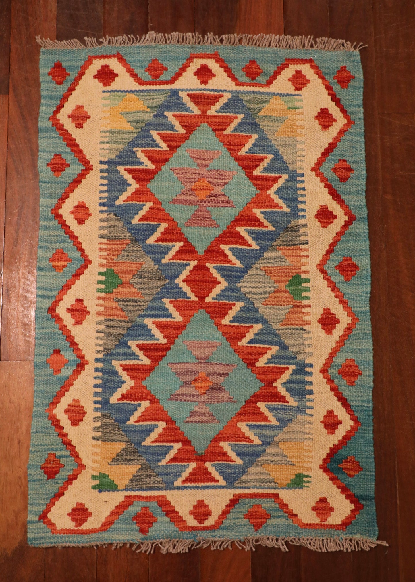  The Afghan Hand Woven Khyber Kilim - 58 X 88. Crafted using traditional vegetable dyed wool, and featuring traditional geometric designs. Colours, Dark oranges, creams, light greens, light blues yellows. Size 58 X 88. Top.