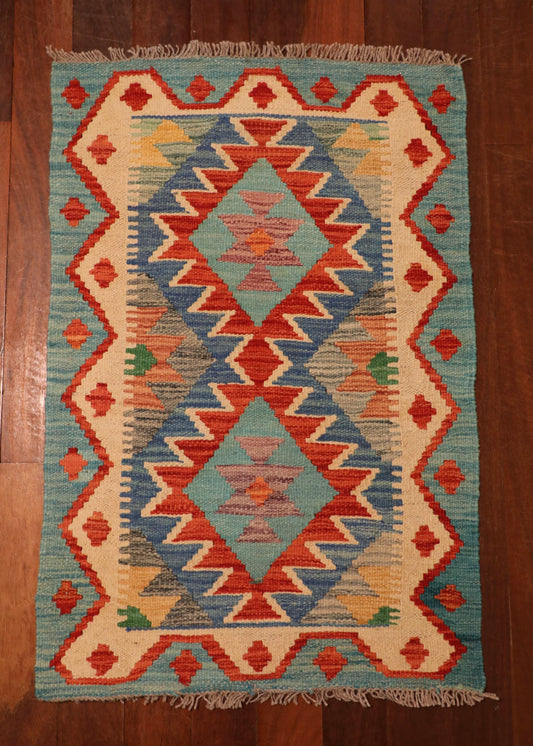  The Afghan Hand Woven Khyber Kilim - 58 X 88. Crafted using traditional vegetable dyed wool, and featuring traditional geometric designs. Colours, Dark oranges, creams, light greens, light blues yellows. Size 58 X 88. Top.