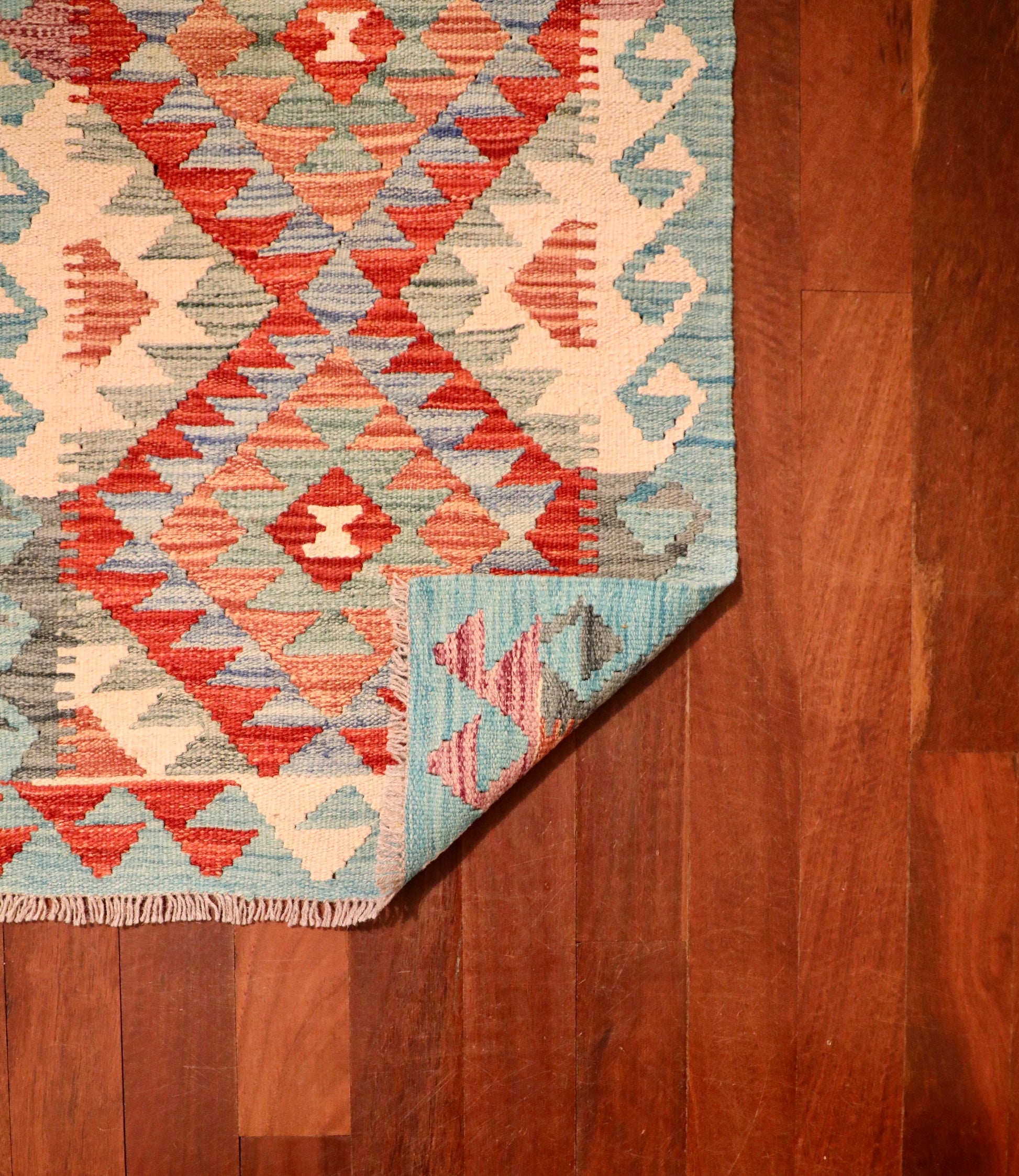 The Afghan Hand Woven Khyber Kilim - 59 X 88. Crafted using traditional vegetable dyed wool, and featuring traditional geometric designs. Colours, oranges, creams, light greens, light blues. Size 59 X 88. Fold.