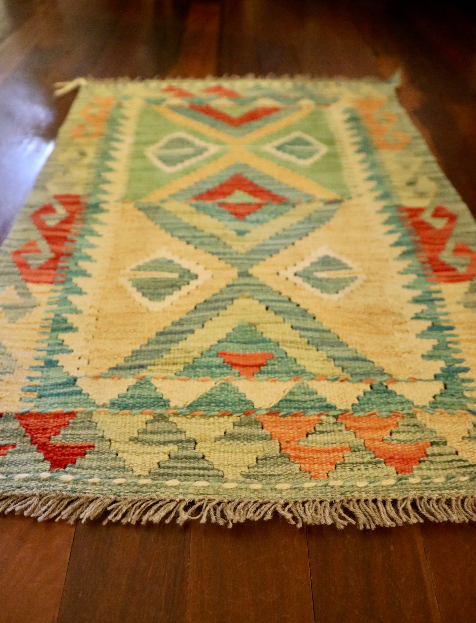  The Afghan Hand Woven Khyber Kilim - 60 X 84. Crafted using traditional vegetable dyed wool, and featuring traditional geometric designs. Colours, Dark oranges, creams, light greens, light blues yellows. Size 60 X 84. Angle.