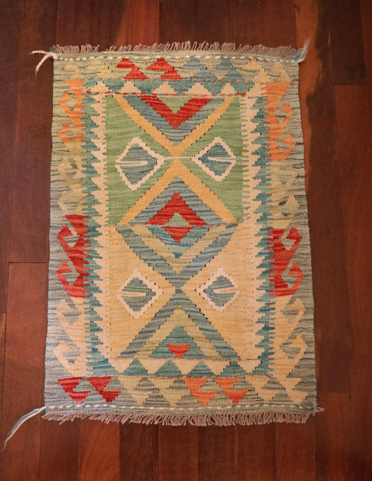  The Afghan Hand Woven Khyber Kilim - 60 X 84. Crafted using traditional vegetable dyed wool, and featuring traditional geometric designs. Colours, Dark oranges, creams, light greens, light blues yellows. Size 60 X 84. Top.