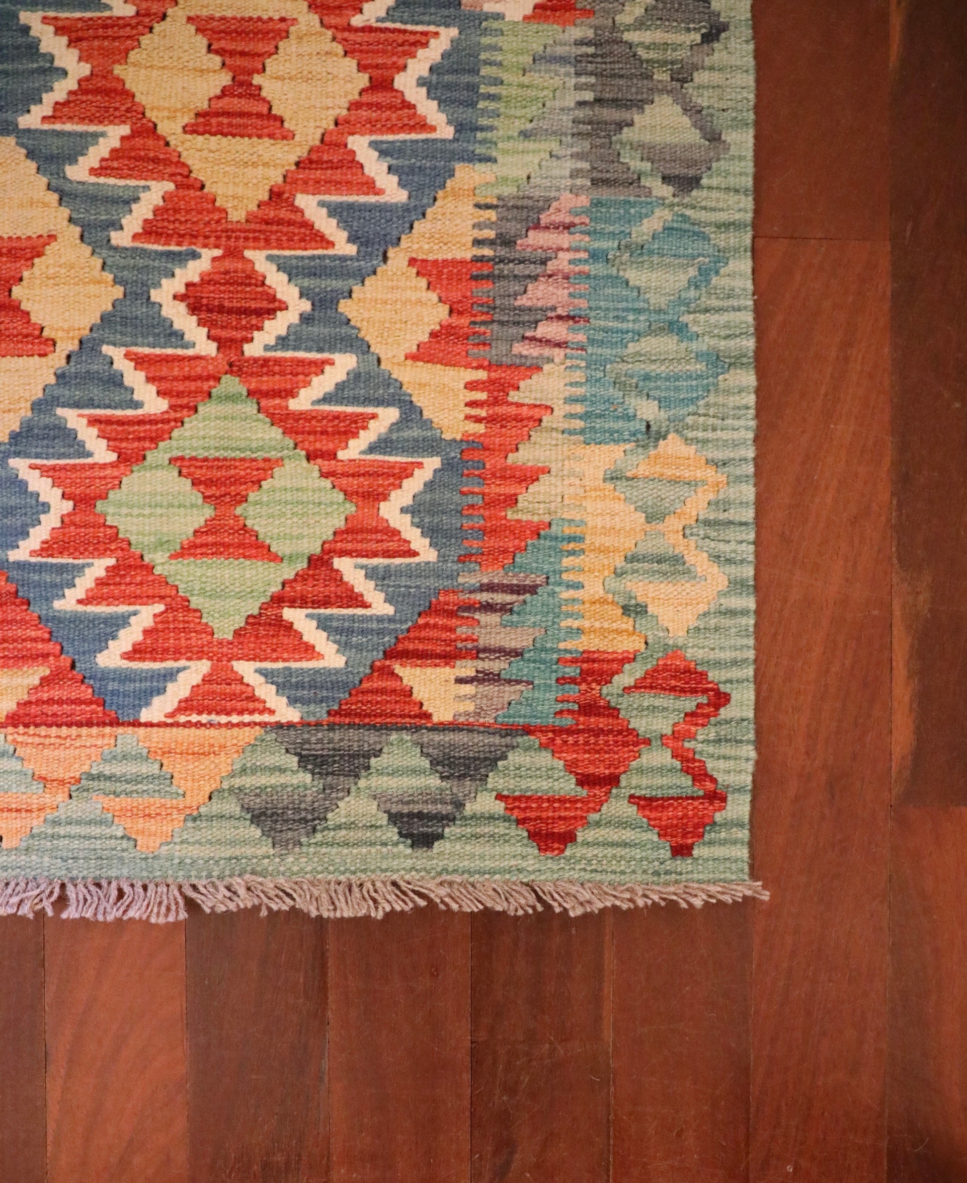  The Afghan Hand Woven Khyber Kilim - 60 X 85. Crafted using traditional vegetable dyed wool, and featuring traditional geometric designs. Colours, Dark oranges, creams, light greens, light blues yellows. Size 60 X 85. Corner.