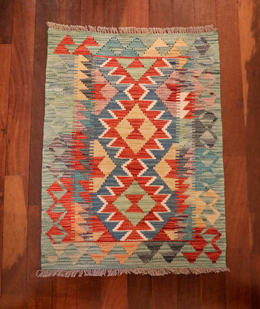  The Afghan Hand Woven Khyber Kilim - 60 X 85. Crafted using traditional vegetable dyed wool, and featuring traditional geometric designs. Colours, Dark oranges, creams, light greens, light blues yellows. Size 60 X 85. Top.