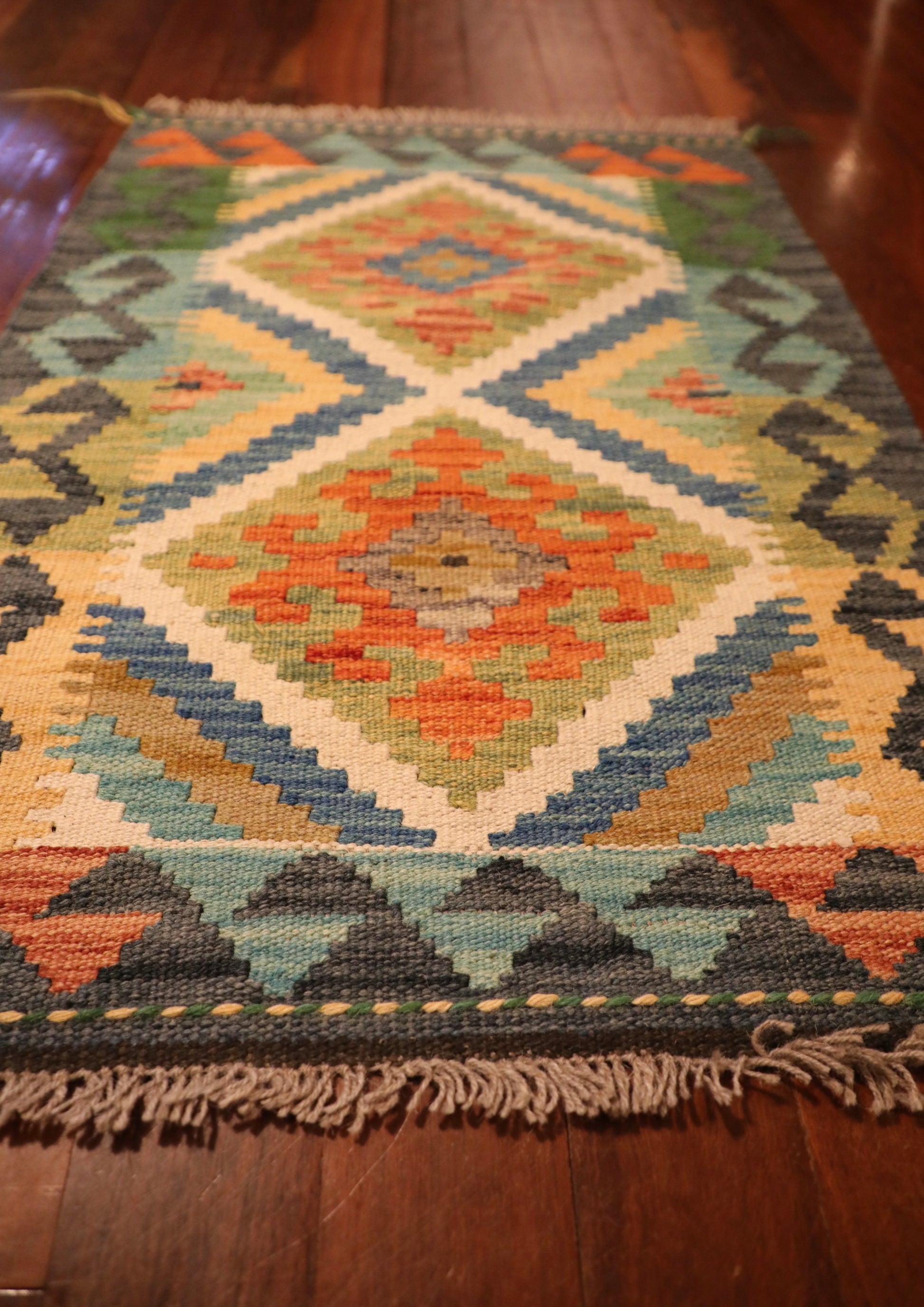 The Afghan Hand Woven Khyber Kilim - 60 X 87. Crafted using traditional vegetable dyed wool, and featuring traditional geometric designs. Colours, dark greys, beiges, blues, creams, light greens, light blues and yellows. Size 60 X 87. Angle.