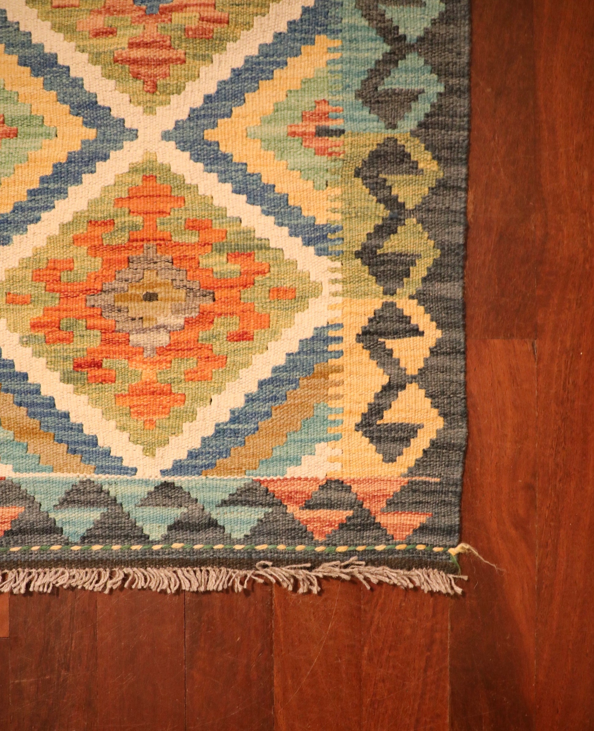 The Afghan Hand Woven Khyber Kilim - 60 X 87. Crafted using traditional vegetable dyed wool, and featuring traditional geometric designs. Colours, dark greys, beiges, blues, creams, light greens, light blues and yellows. Size 60 X 87. Corner.