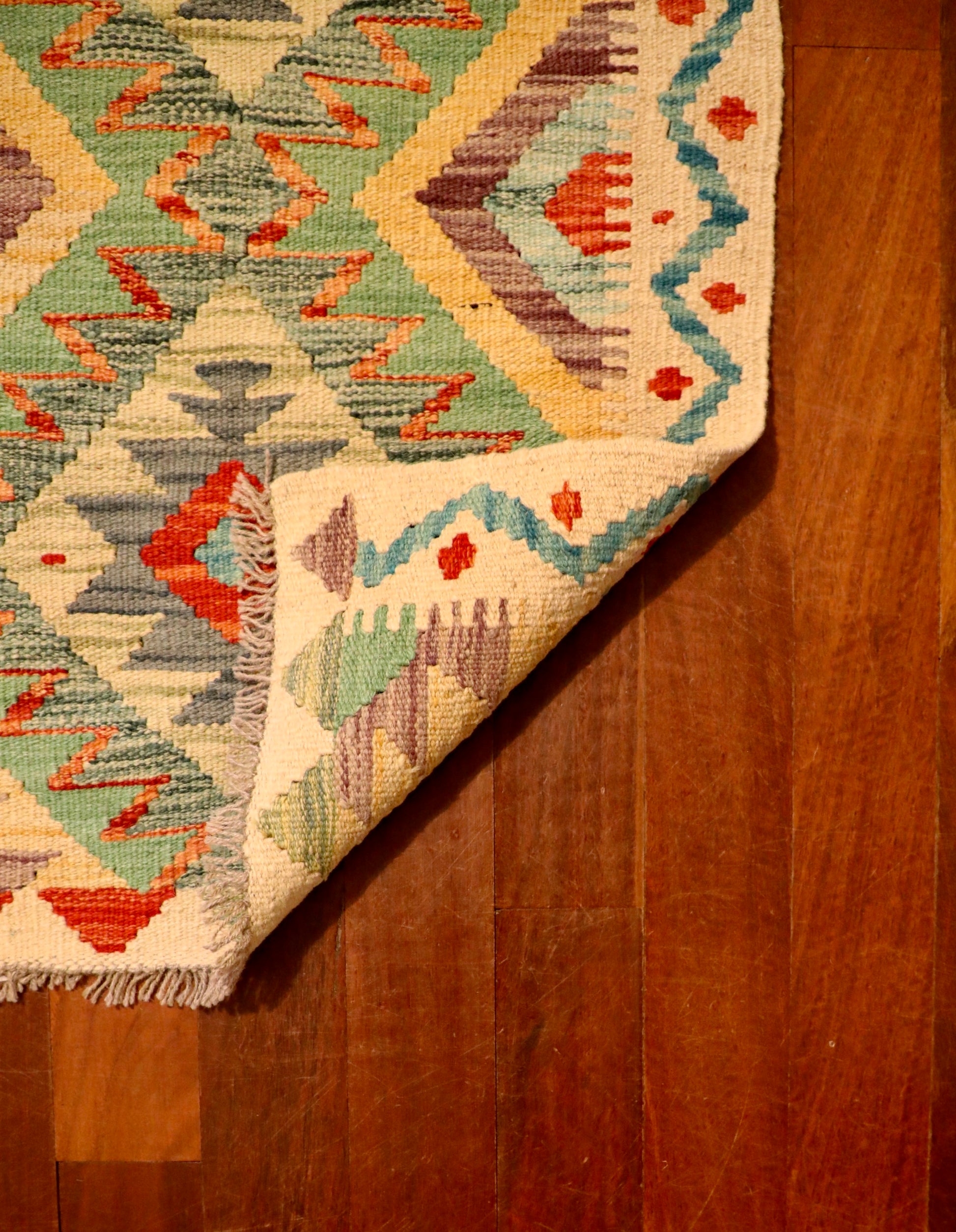 The Afghan Hand Woven Khyber Kilim 60 X 90. Crafted using traditional vegetable dyed wool, and featuring traditional geometric designs. Colours, beige, greens, light blues, yellows and reds. Size 60 X 90. Fold.