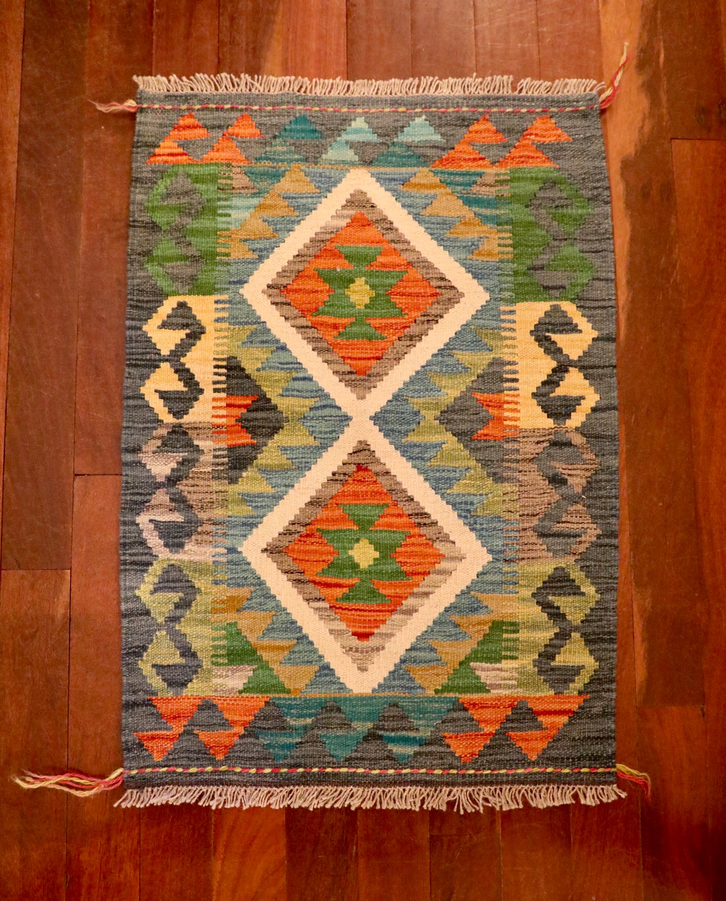 The Afghan Hand Woven Khyber Kilim - 61 X 86. Crafted using traditional vegetable dyed wool, and featuring traditional geometric designs. Colours, dark greys, beiges, blues, creams, light greens, light blues and yellows. Size 61 X 86. Top.