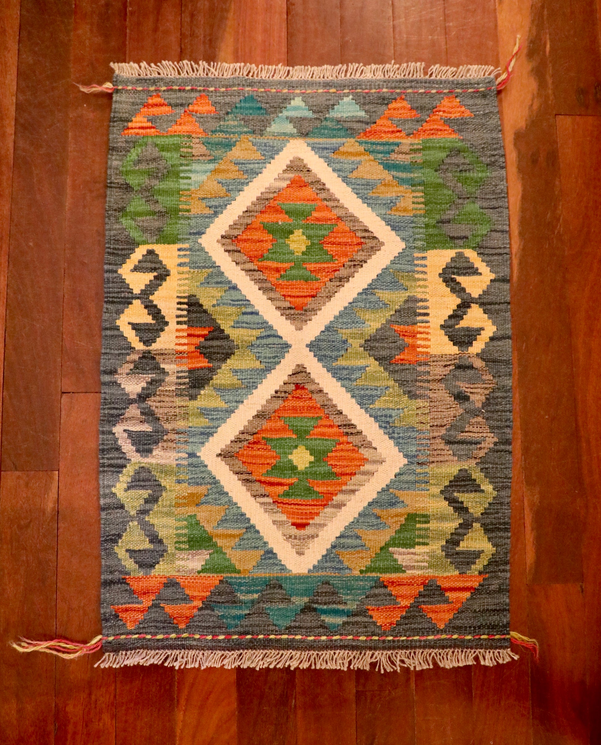 The Afghan Hand Woven Khyber Kilim - 61 X 86. Crafted using traditional vegetable dyed wool, and featuring traditional geometric designs. Colours, dark greys, beiges, blues, creams, light greens, light blues and yellows. Size 61 X 86. Top.