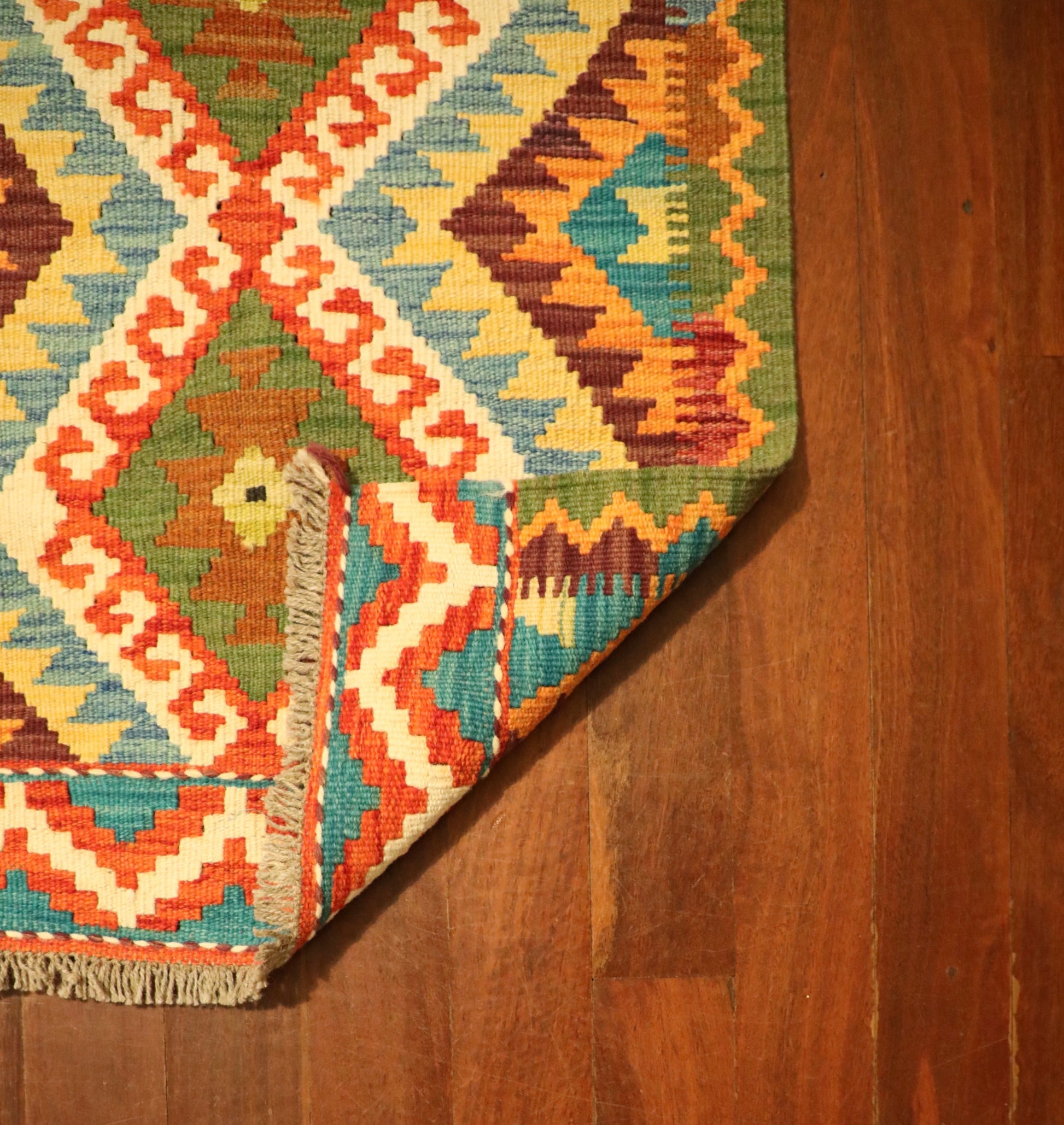 The Afghan Hand Woven Khyber Kilim - 62 X 87. Crafted using traditional vegetable dyed wool, and featuring traditional geometric designs. Colours, reds, beiges, creams, oranges, light greens, light blues and yellows. Size 62 X 87. Fold.