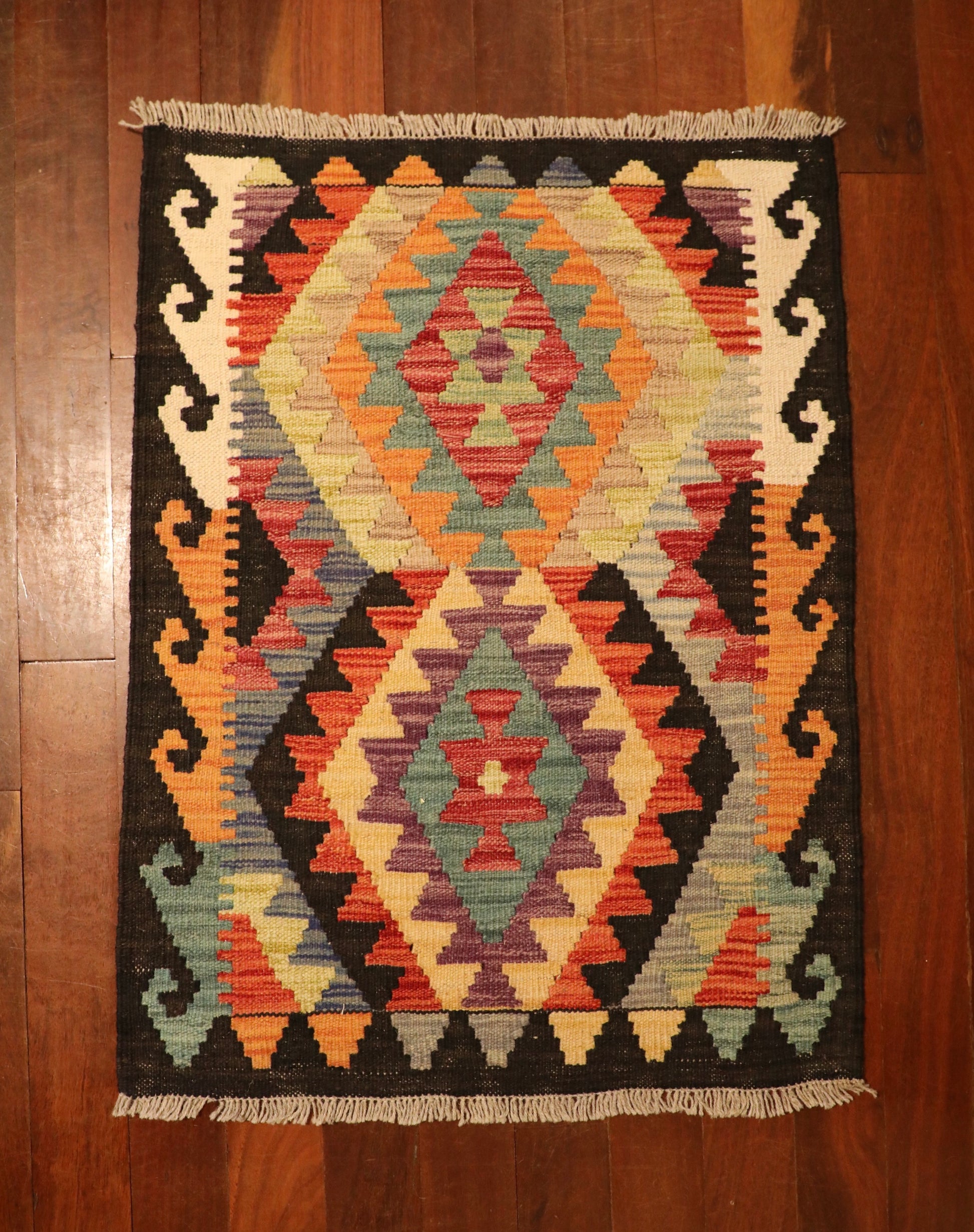 The Afghan Hand Woven Khyber Kilim - 65 X 87. Crafted using traditional vegetable dyed wool, and featuring traditional geometric designs. Colours, navy blue, reds, beiges, creams, oranges, light greens, light blues and yellows. Size 65 X 87. Top.