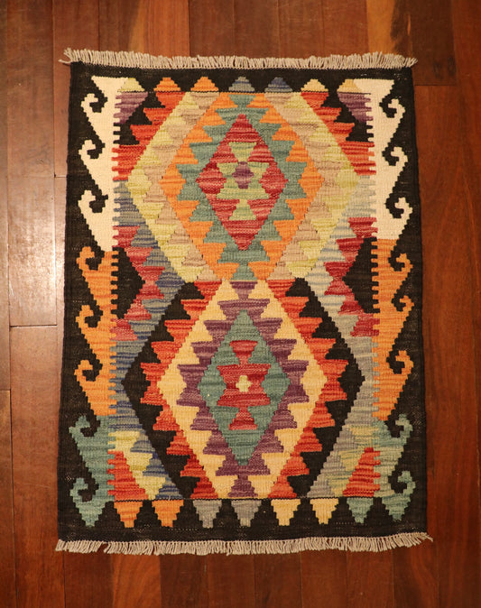 The Afghan Hand Woven Khyber Kilim - 65 X 87. Crafted using traditional vegetable dyed wool, and featuring traditional geometric designs. Colours, navy blue, reds, beiges, creams, oranges, light greens, light blues and yellows. Size 65 X 87. Top.