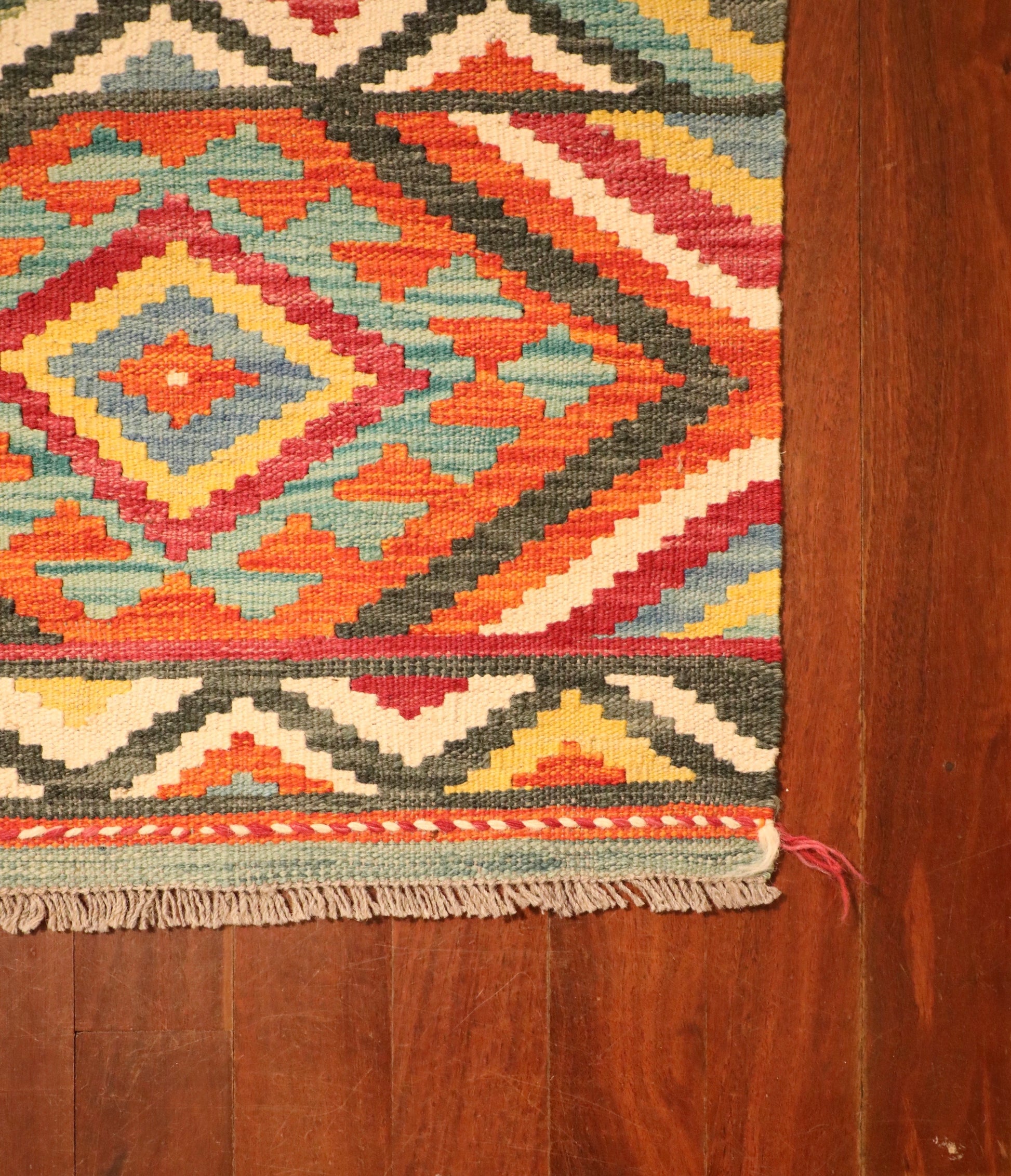 The Afghan Hand Woven Khyber Kilim - 65 X 90. Crafted using traditional vegetable dyed wool, and featuring traditional geometric designs. Colours, reds, beiges, creams, light greens, light blues and yellows. Size 65 X 90. Corner.