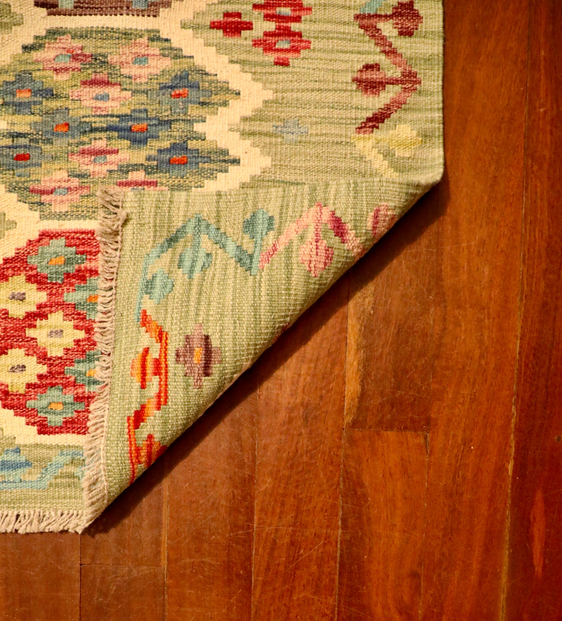 The Afghan Hand Woven Khyber Kilim - 65 X 92. Crafted using traditional vegetable dyed wool, and featuring traditional geometric designs. Colours, light greens, light blues, reds, beiges, creams, oranges and yellows. Size 65 X 92. Fold.
