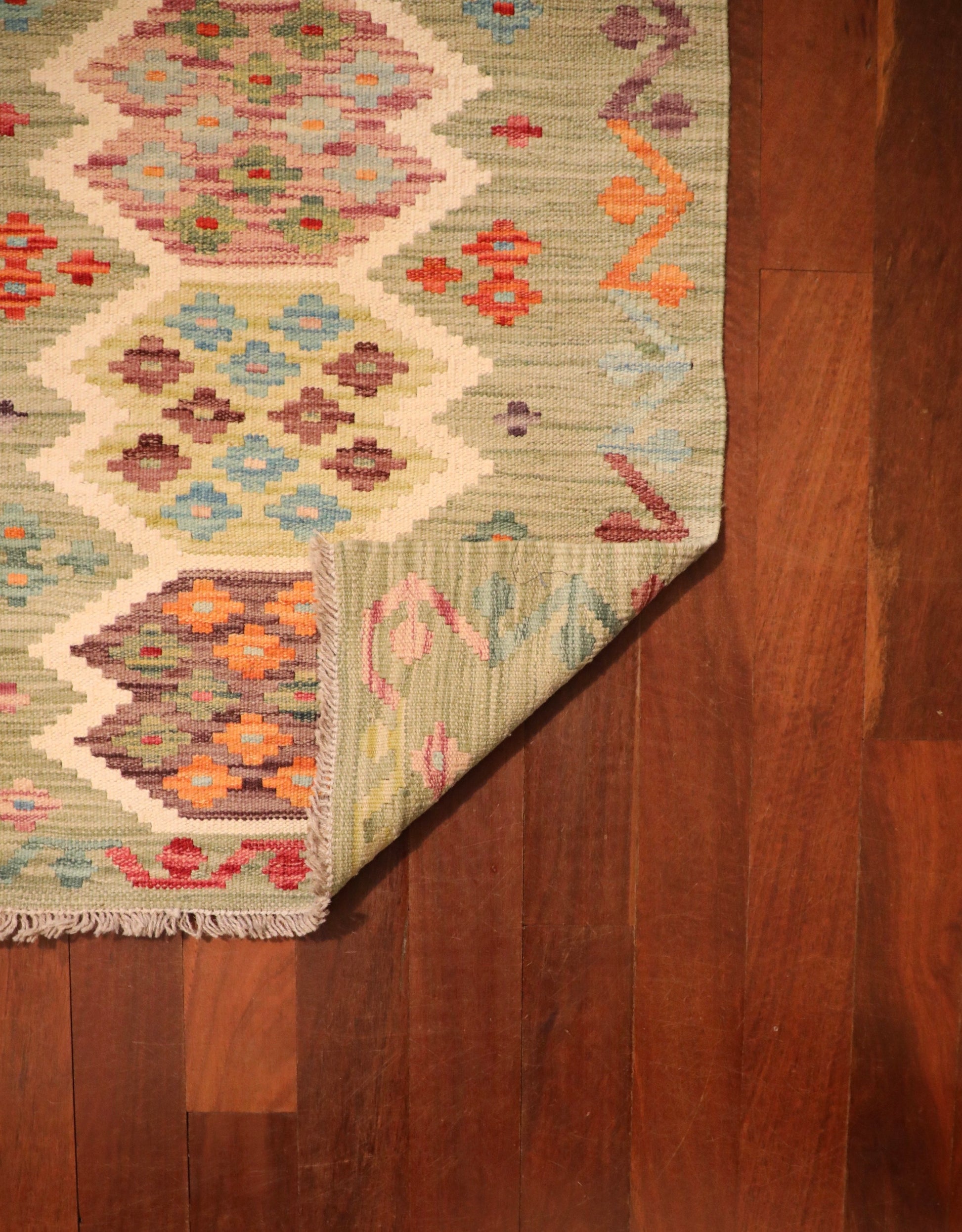 The Afghan Hand Woven Khyber Kilim - 67 X 94. Crafted using traditional vegetable dyed wool, and featuring traditional geometric designs. Colours, light greens, creams, light blues, reds and orange. Size 67 X 94. Fold.