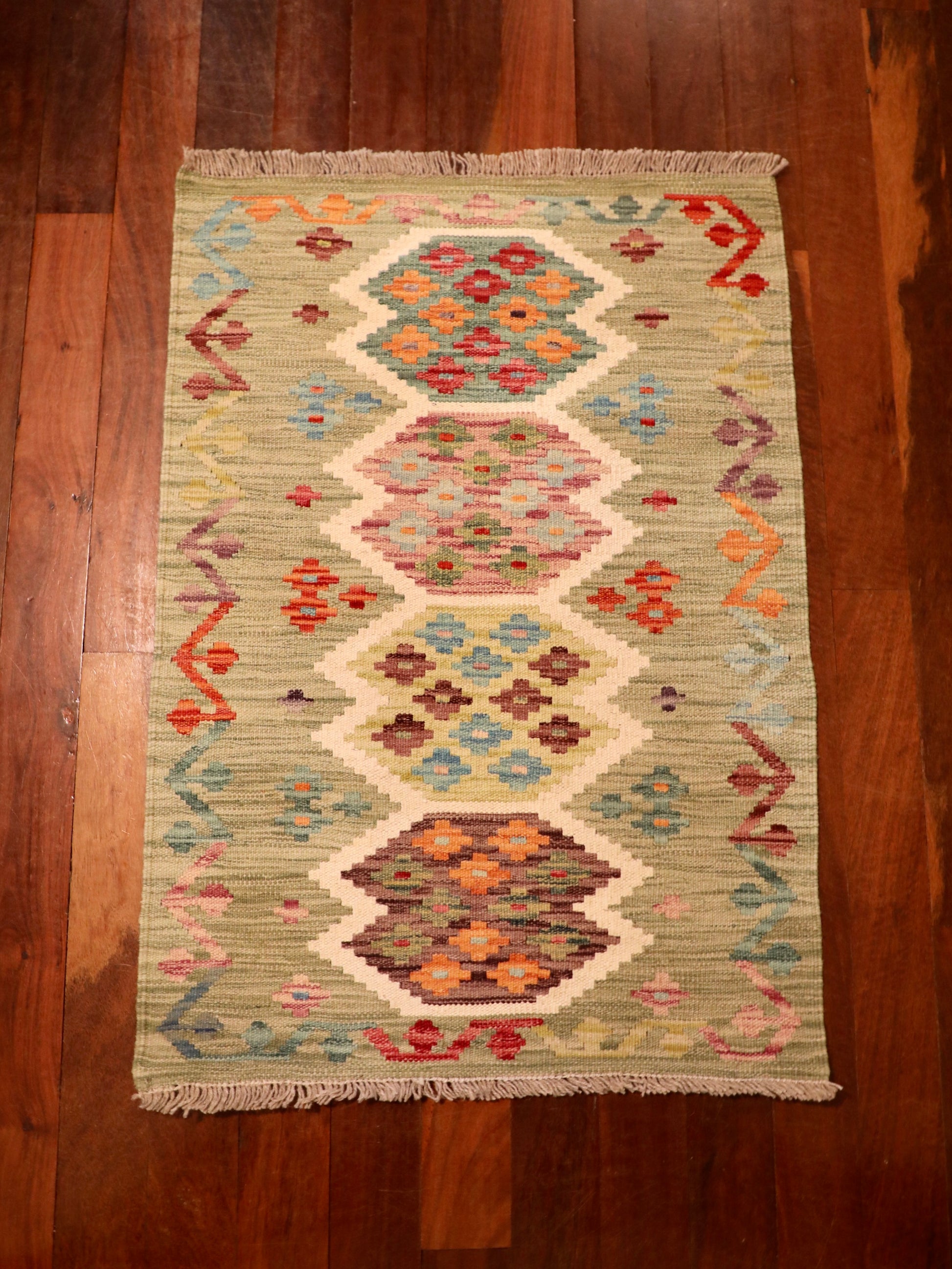 The Afghan Hand Woven Khyber Kilim - 67 X 94. Crafted using traditional vegetable dyed wool, and featuring traditional geometric designs. Colours, light greens, creams, light blues, reds and orange. Size 67 X 94. Top.
