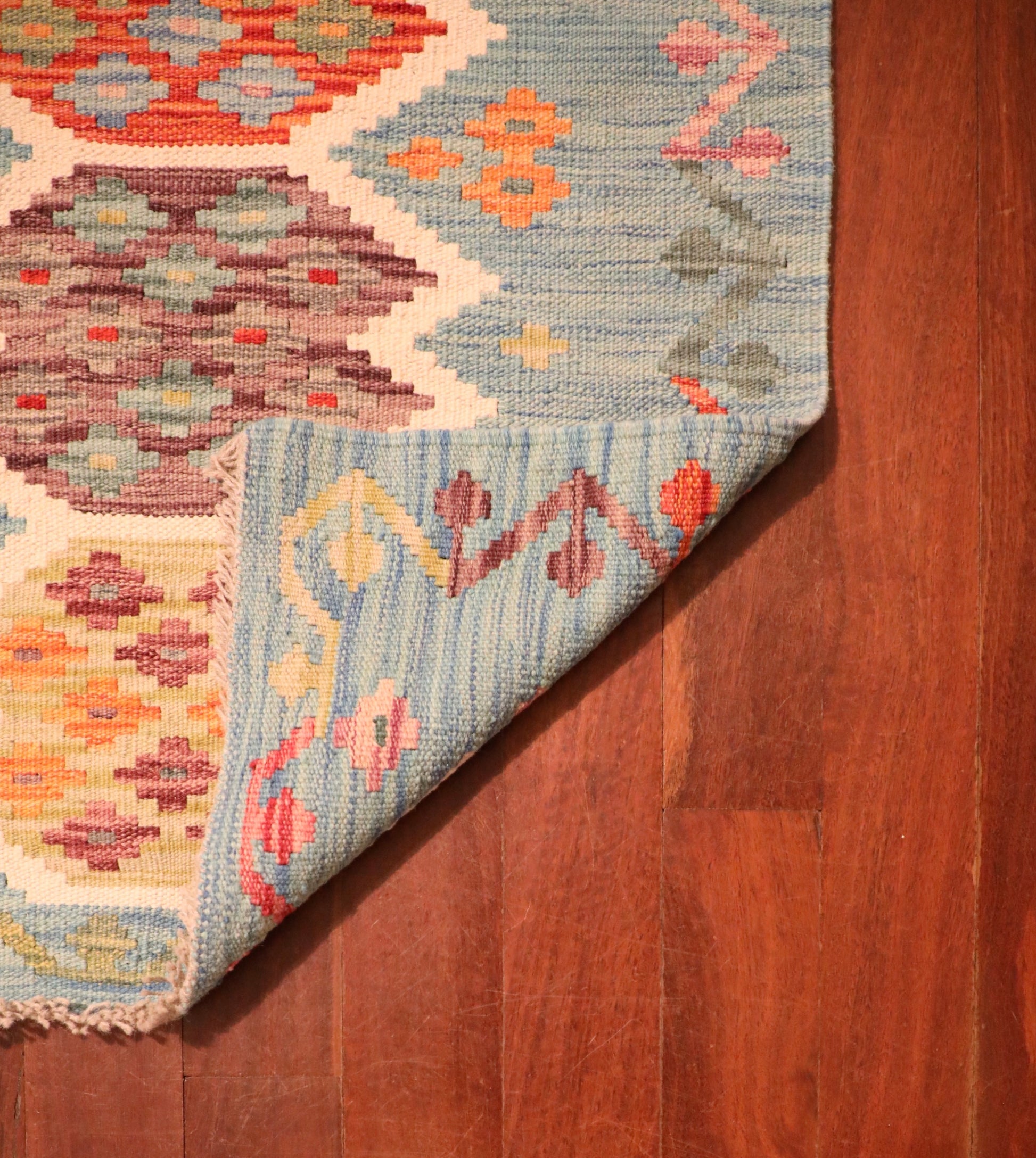 The Afghan Hand Woven Khyber Kilim - 68 X 92. Crafted using traditional vegetable dyed wool, and featuring traditional geometric designs. Colours, teal green, light blues, reds, beiges, creams, oranges and yellows. Size 68 X 92. Fold.