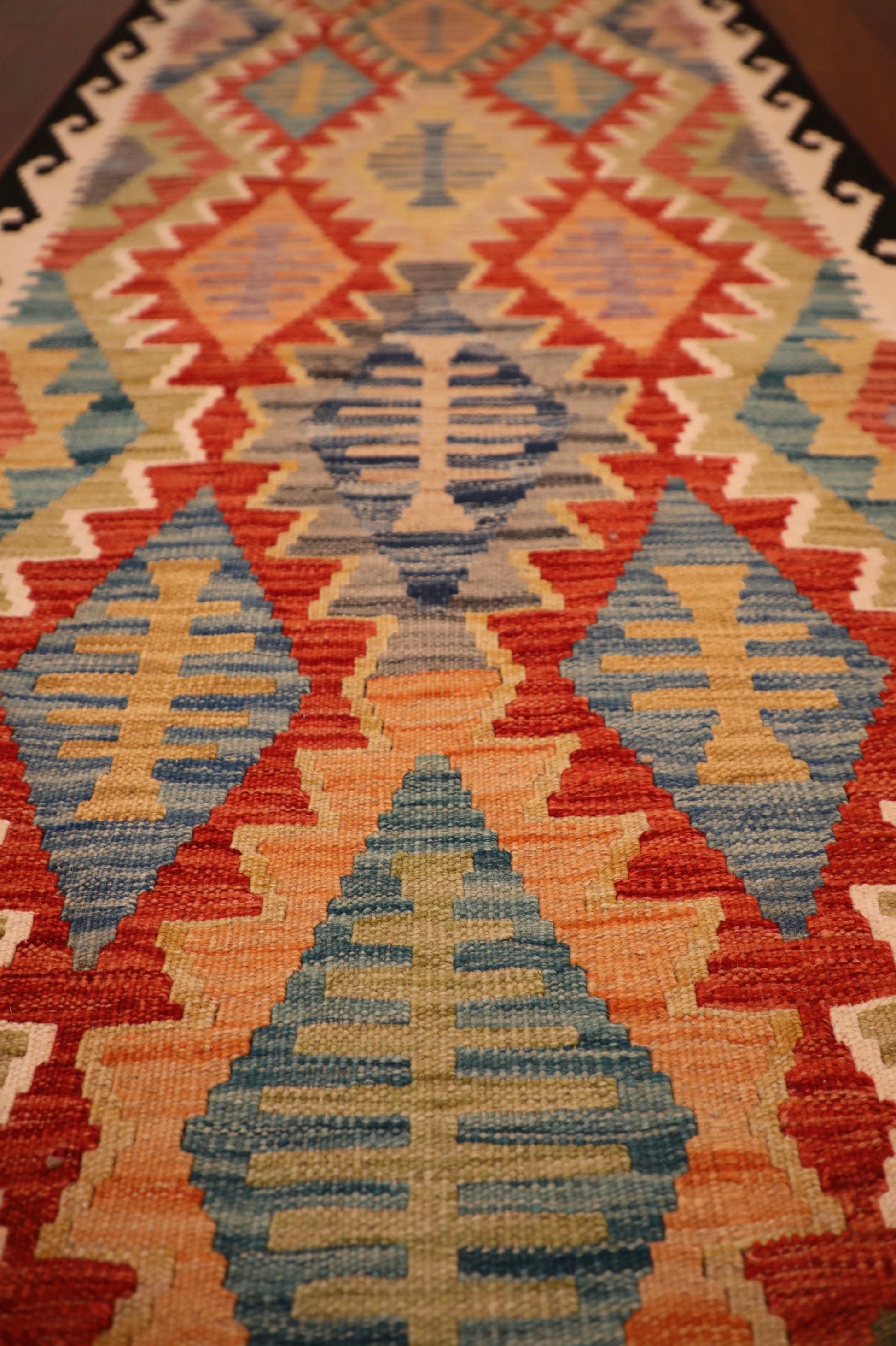 The Afghan Hand Woven Khyber Kilim Runner - 79 X 293.  Crafted using traditional vegetable dyed wool, and featuring traditional geometric designs. Colours, dark blue, creams, beiges, oranges, light greens and more. Measures 79 wide X 293 long. Close.