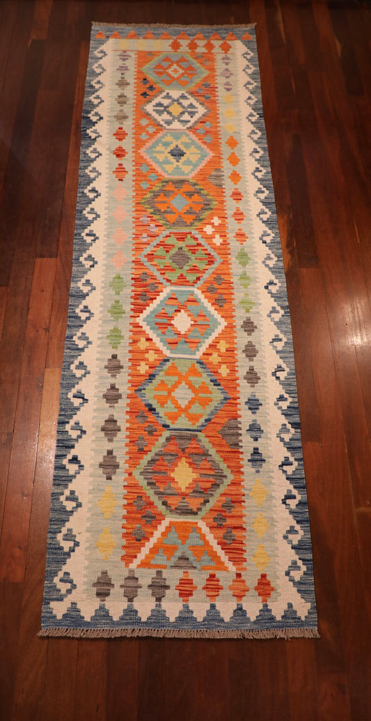 The Afghan Hand Woven Khyber Kilim Runner - 82 X 283.  Crafted using traditional vegetable dyed wool, and featuring traditional geometric designs. Colours, blues, yellows, creams, beiges, oranges and more. Measures 82 wide X 283 long. Top.