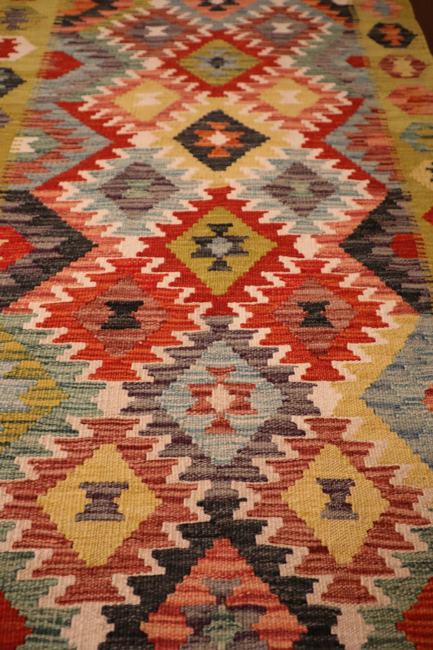 The Afghan Hand Woven Khyber Kilim Runner - 86 X 290.  Crafted using traditional vegetable dyed wool, and featuring traditional geometric designs. Colours, yellows, creams, beiges, oranges, blues and more. Measures 86 wide X 290 long. Close.