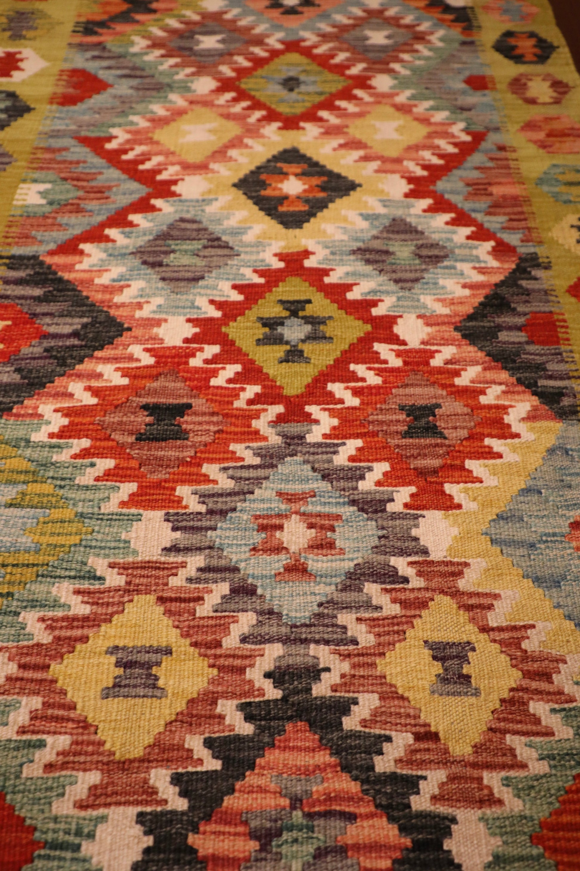 The Afghan Hand Woven Khyber Kilim Runner - 86 X 290.  Crafted using traditional vegetable dyed wool, and featuring traditional geometric designs. Colours, yellows, creams, beiges, oranges, blues and more. Measures 86 wide X 290 long. Close.