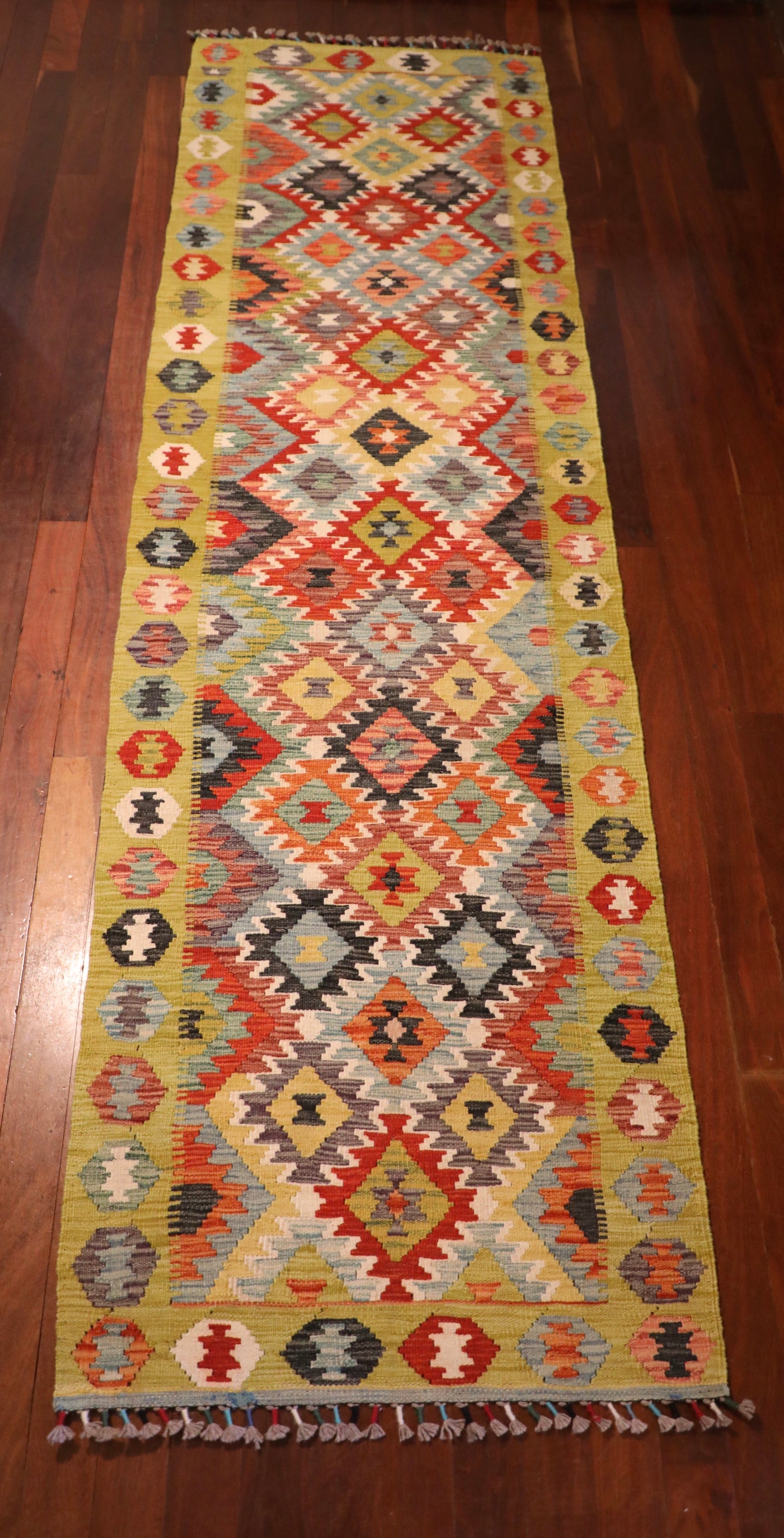 The Afghan Hand Woven Khyber Kilim Runner - 86 X 290.  Crafted using traditional vegetable dyed wool, and featuring traditional geometric designs. Colours, yellows, creams, beiges, oranges, blues and more. Measures 86 wide X 290 long. Top.