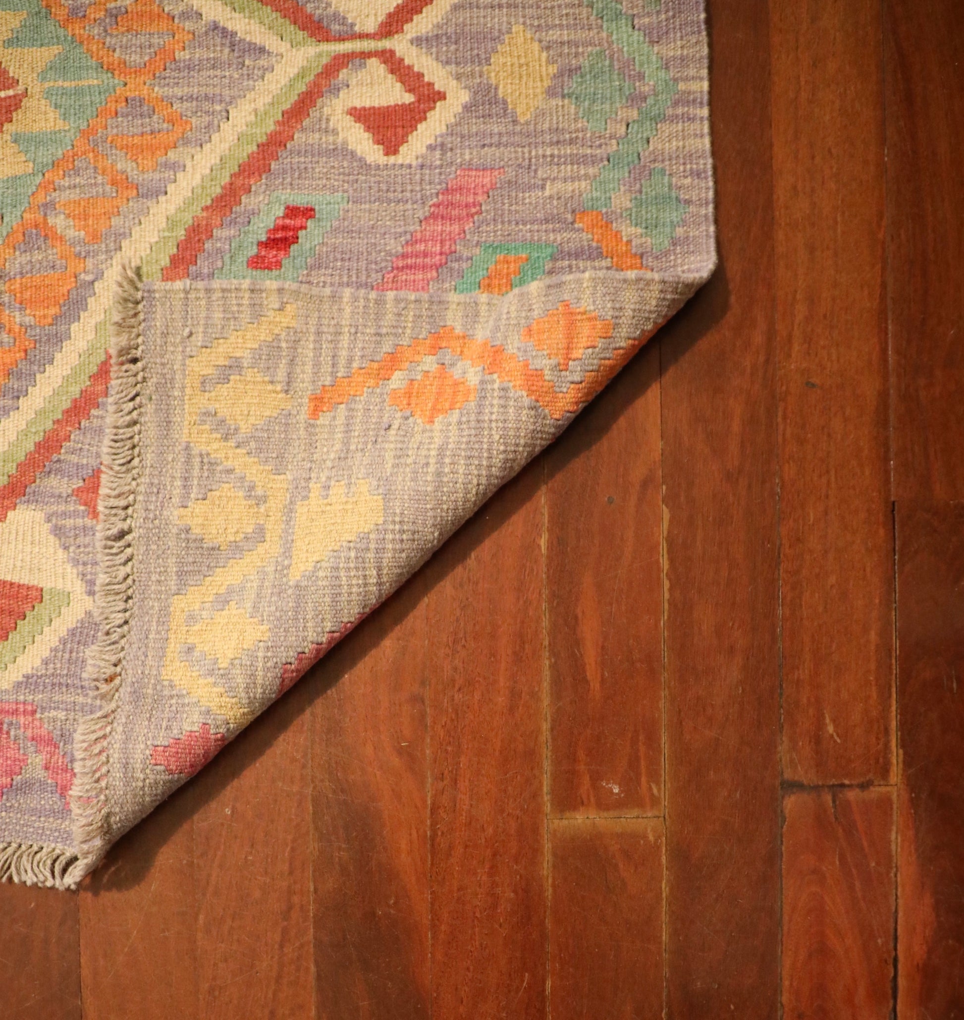 The Afghan Hand Woven Khyber Kilim - 127 X 174. Crafted using traditional vegetable dyed wool, and featuring traditional geometric designs. Colours, lavenders, beiges, creams, oranges. Size 127 X 174. Fold.
