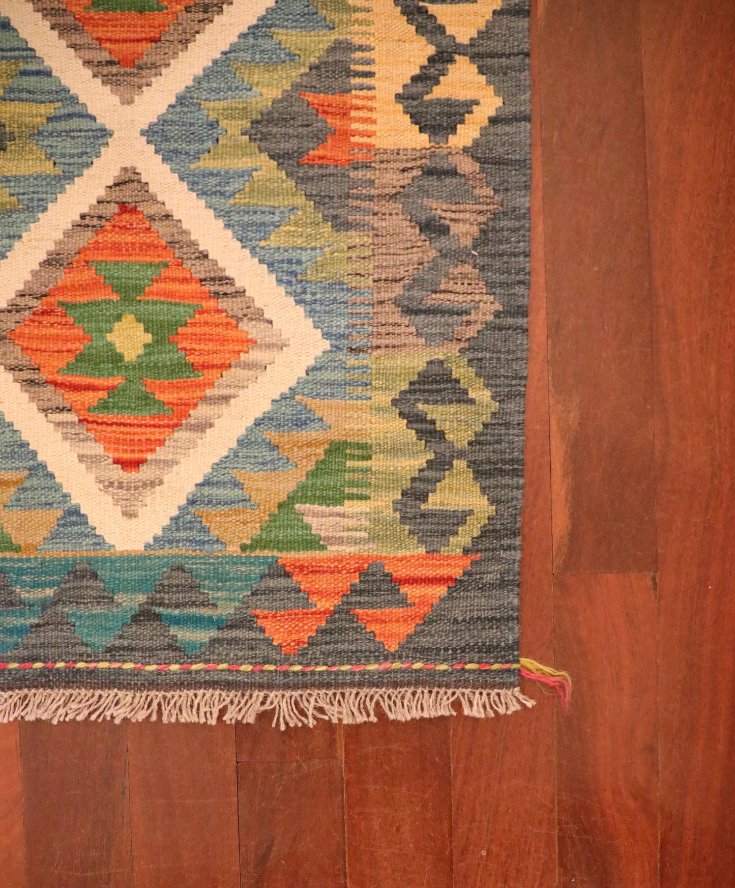 The Afghan Hand Woven Khyber Kilim - 61 X 86. Crafted using traditional vegetable dyed wool, and featuring traditional geometric designs. Colours, dark greys, beiges, blues, creams, light greens, light blues and yellows. Size 61 X 86. Corner.
