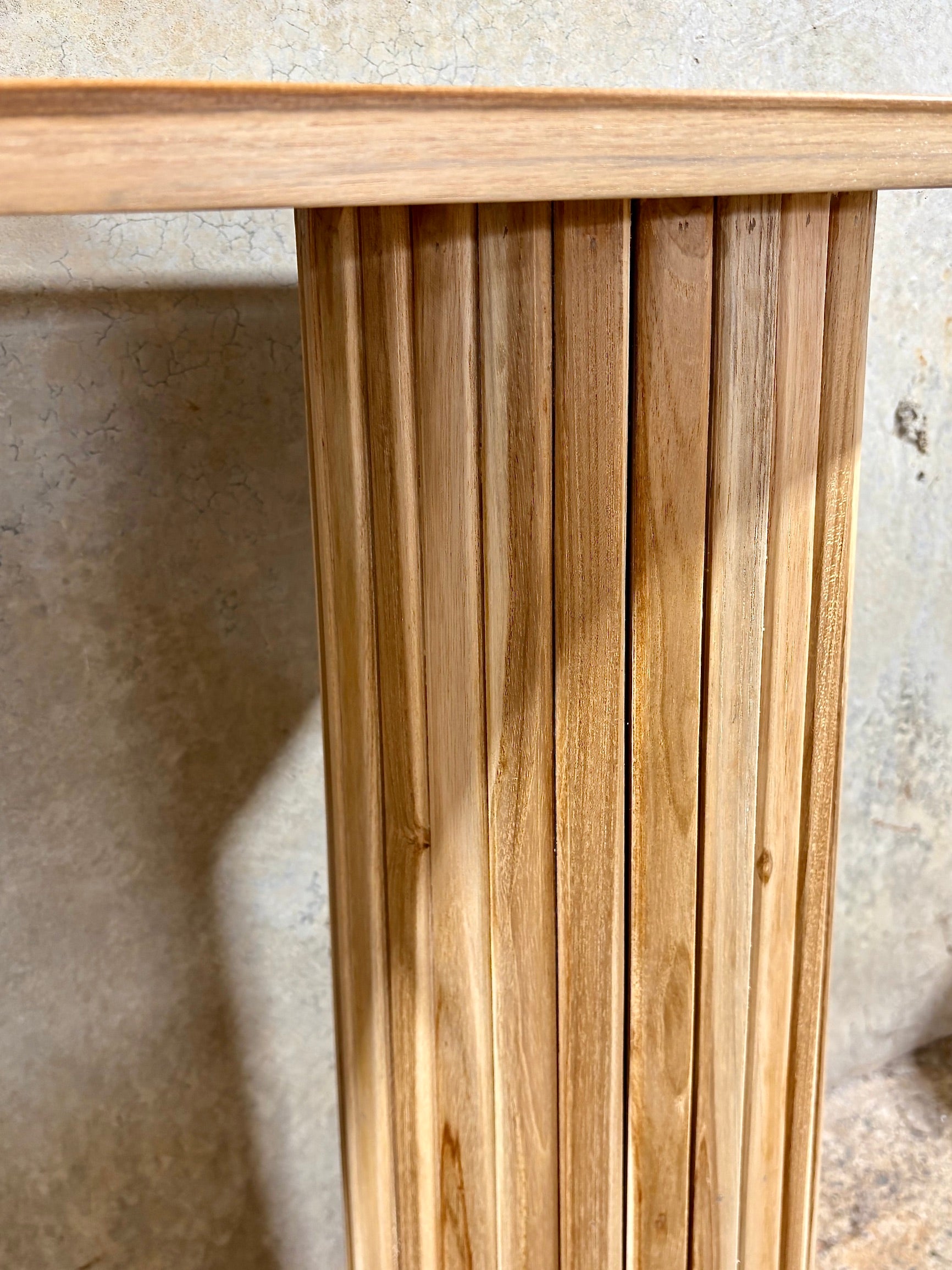 Lisbon console crafted from solid teak featuring textured cylindrical legs and solid top with rounded ends. Colour Natural Teak. Measures 1200 Wide X 350 Depth X 800 Height. Pillar Leg.