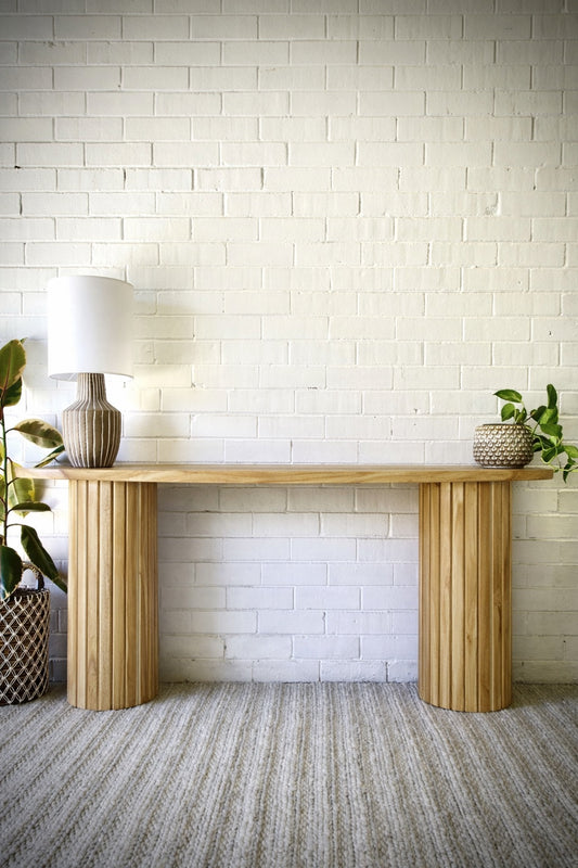 Lisbon console crafted from solid teak featuring textured cylindrical legs and solid top with rounded ends. Colour Natural Teak. Measures 1200 Wide X 350 Depth X 800 Height. Styled.