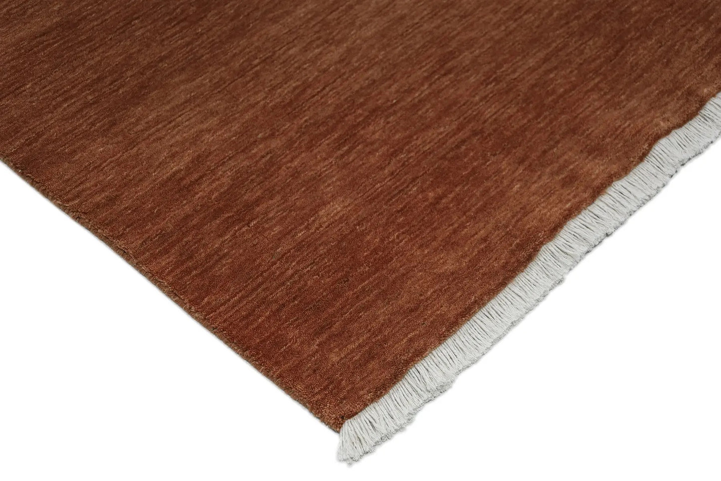 Lori Brick is a luxurious hand loomed floor rug made of 100% wool. The wool material creates a soft texture and a smooth pile height of 16-18mm. Colour orangish/redish terracotta with cream tassels. Sizes 160 X 230, 200 X 290, 240 X 340 and 300 X 400. Corner.