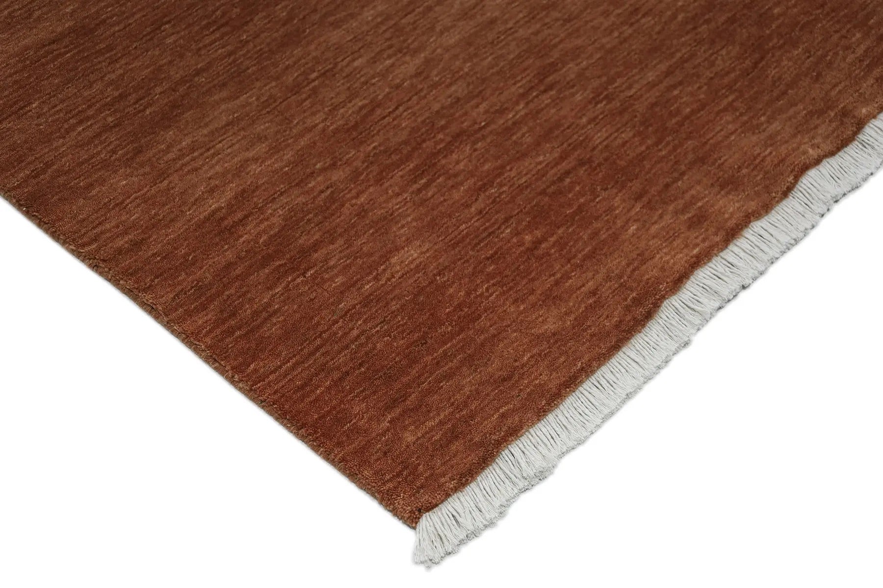 Lori Brick is a luxurious hand loomed floor rug made of 100% wool. The wool material creates a soft texture and a smooth pile height of 16-18mm. Colour orangish/redish terracotta with cream tassels. Sizes 160 X 230, 200 X 290, 240 X 340 and 300 X 400. Corner.