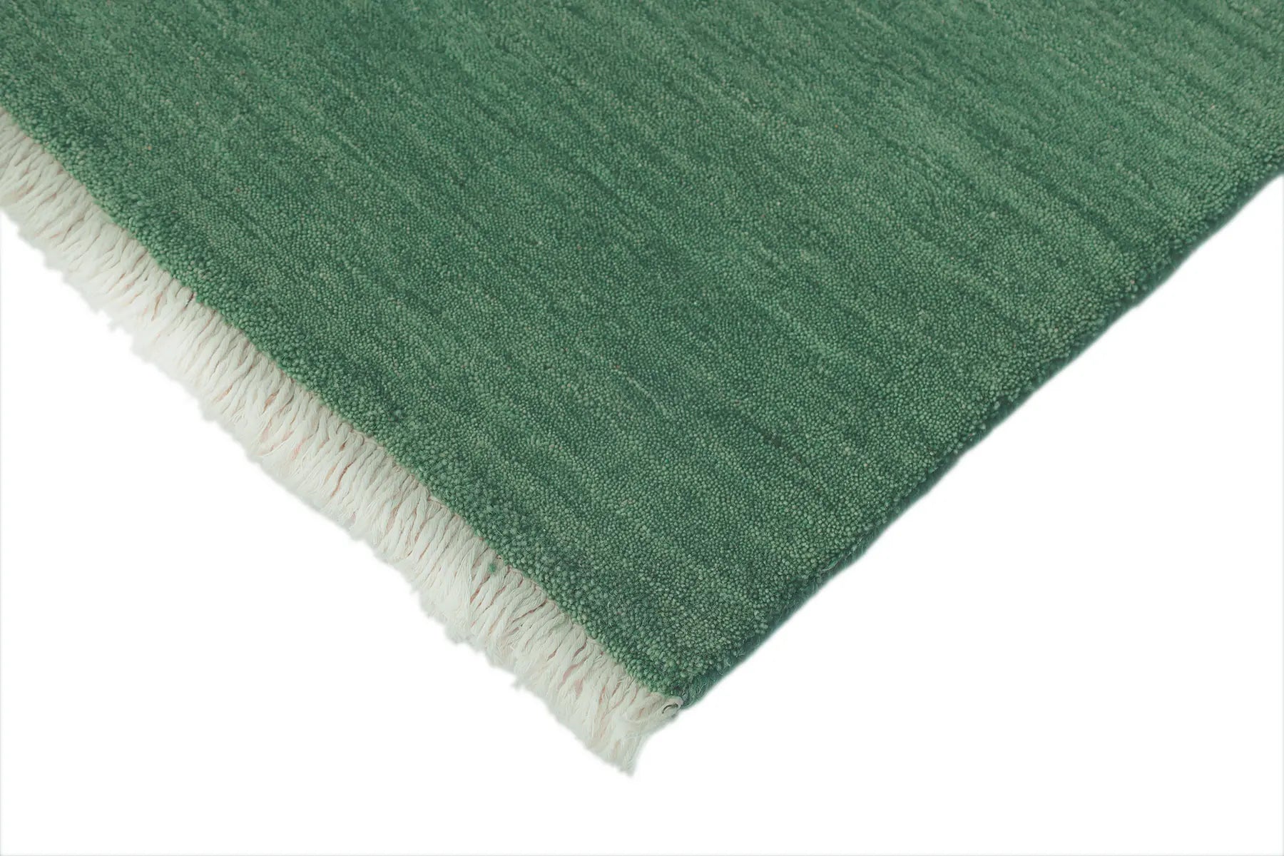 Lori Green is a luxurious hand loomed floor rug made of 100% wool. The wool material creates a soft texture and a smooth pile height of 16-18mm. Colour forrest green with cream tassels. Sizes 160 X 230, 200 X 290, 240 X 340 and 300 X 400. Corner.