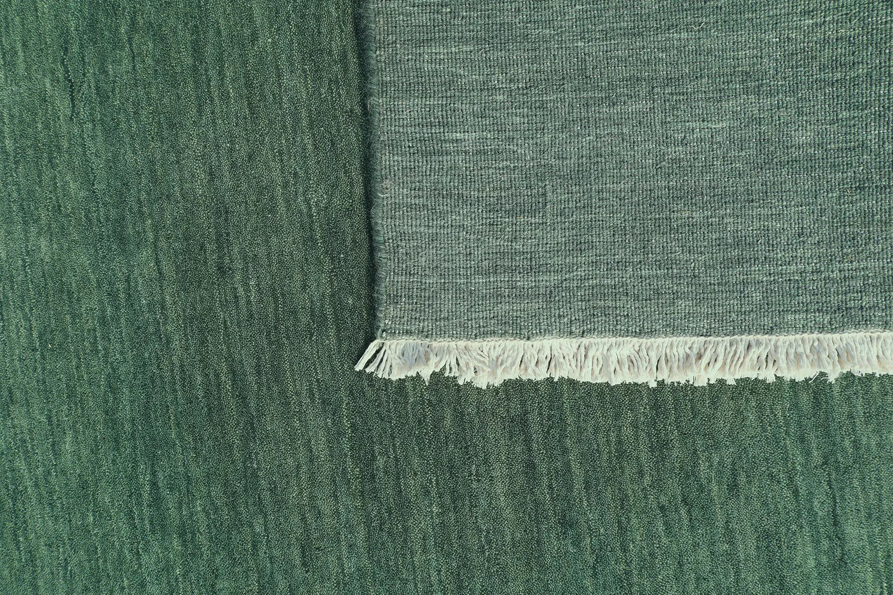 Lori Green is a luxurious hand loomed floor rug made of 100% wool. The wool material creates a soft texture and a smooth pile height of 16-18mm. Colour forrest green with cream tassels. Sizes 160 X 230, 200 X 290, 240 X 340 and 300 X 400. Fold.